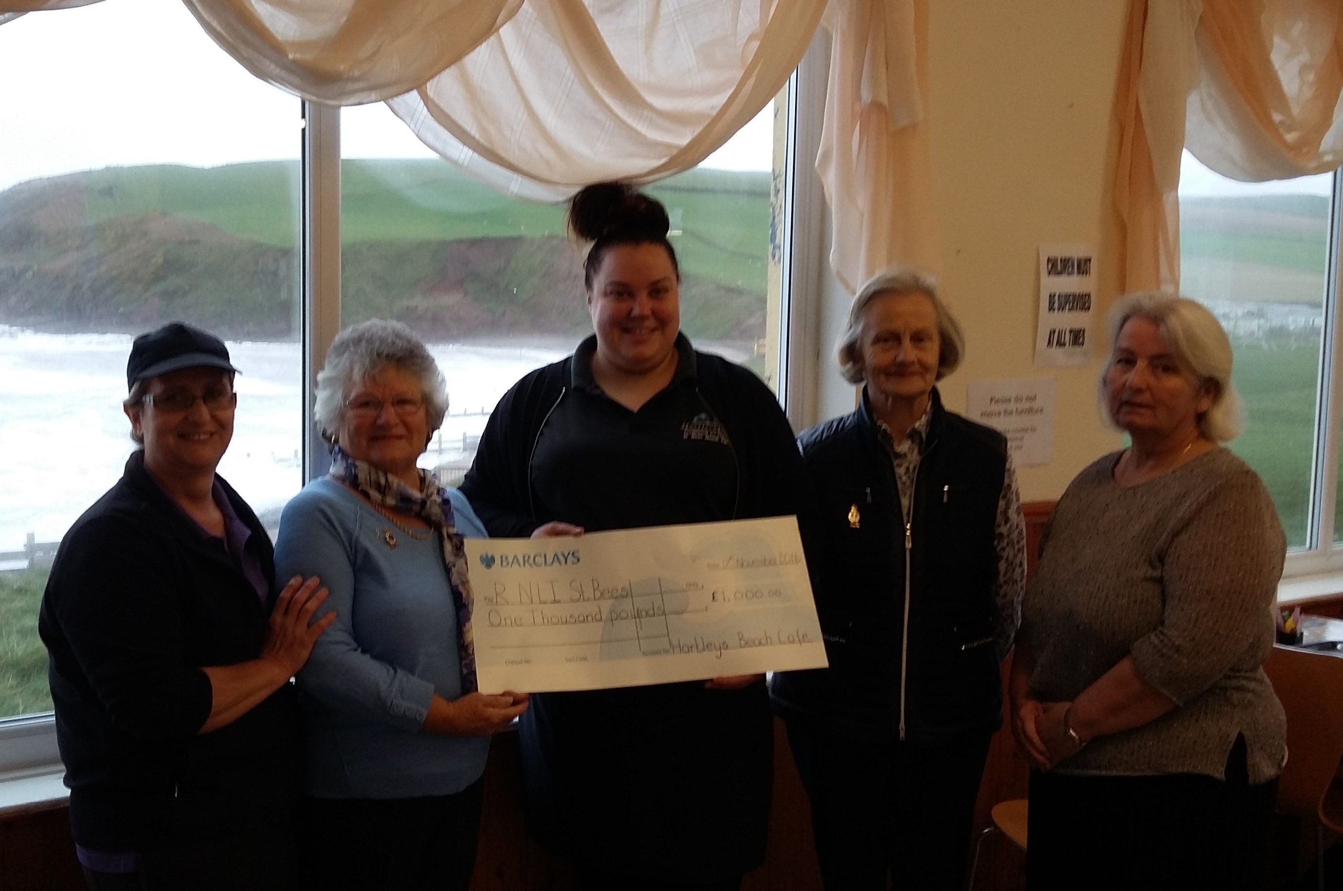 Two members of the staff at Hartleys Beach Cafe and Tea Rooms presenting the cheque for £1000.00 to St Bees Guild members Joyce Ashley, Christine Wrigley and Maria Thurlwell