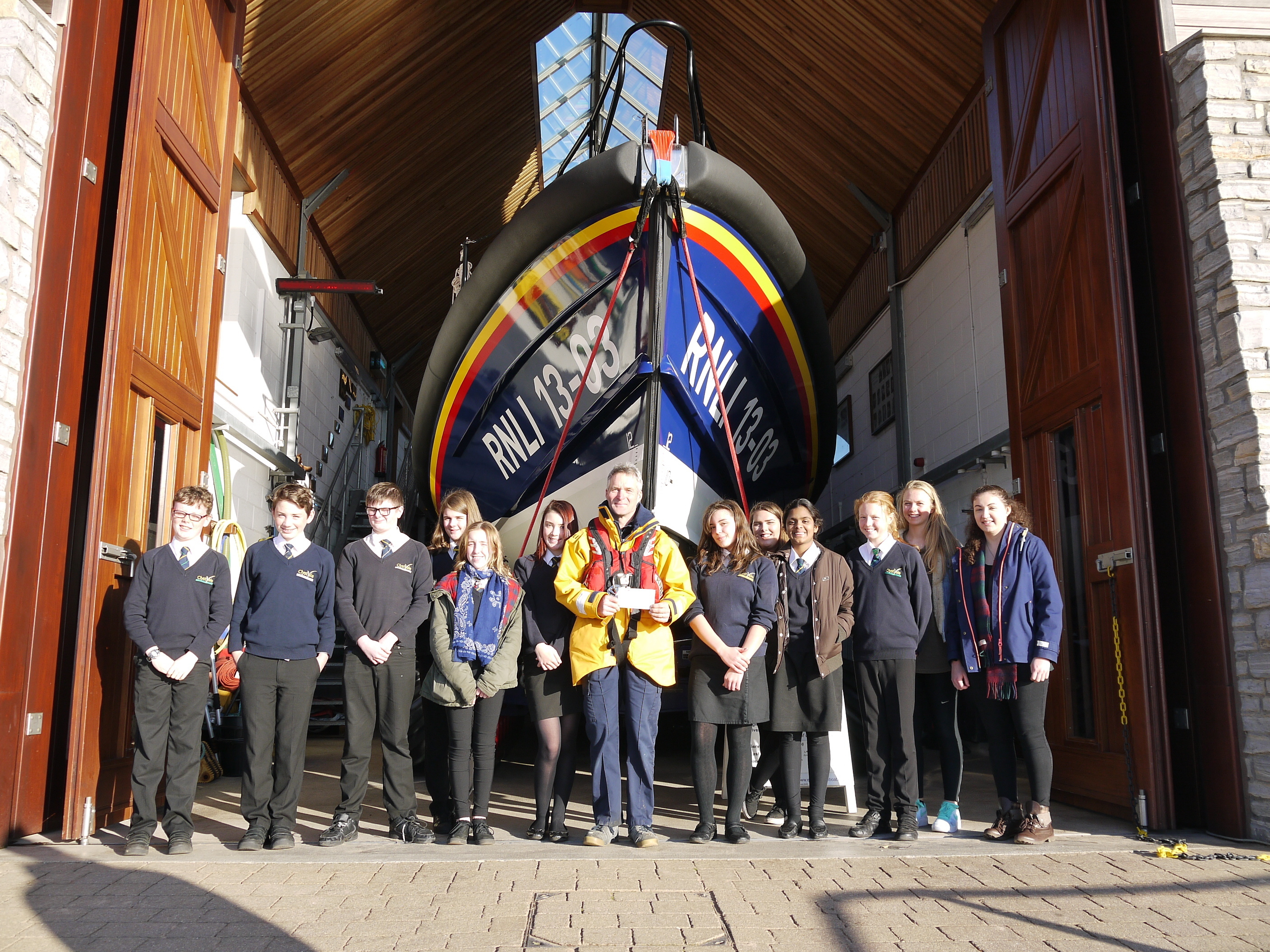 Clyst Vale students present a cheque to Coxswain, Steve Hockings-Thompson