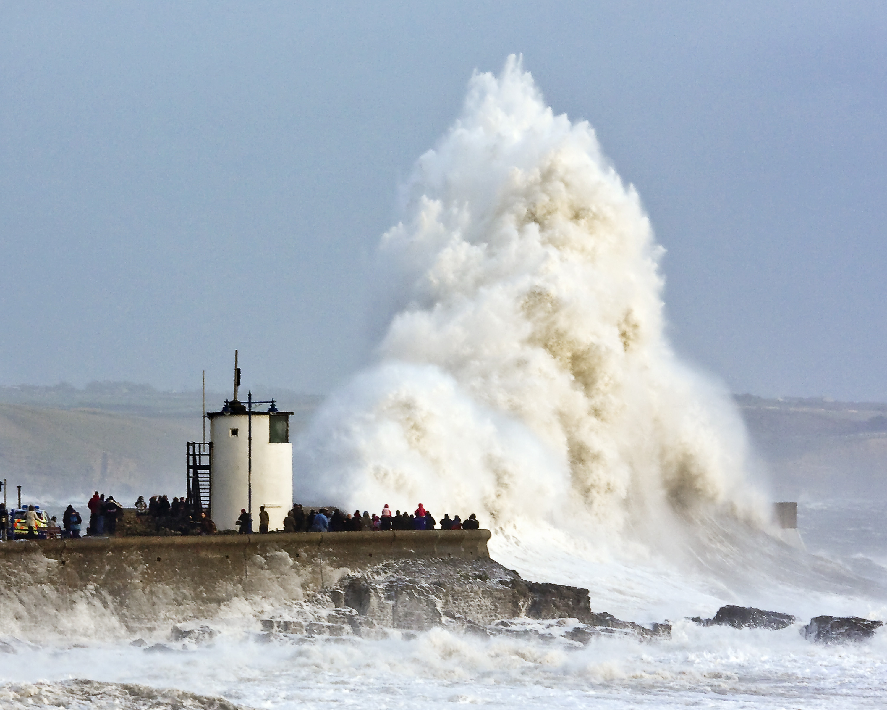 Waves crashing over Porthcawl attract large numbers of spectators