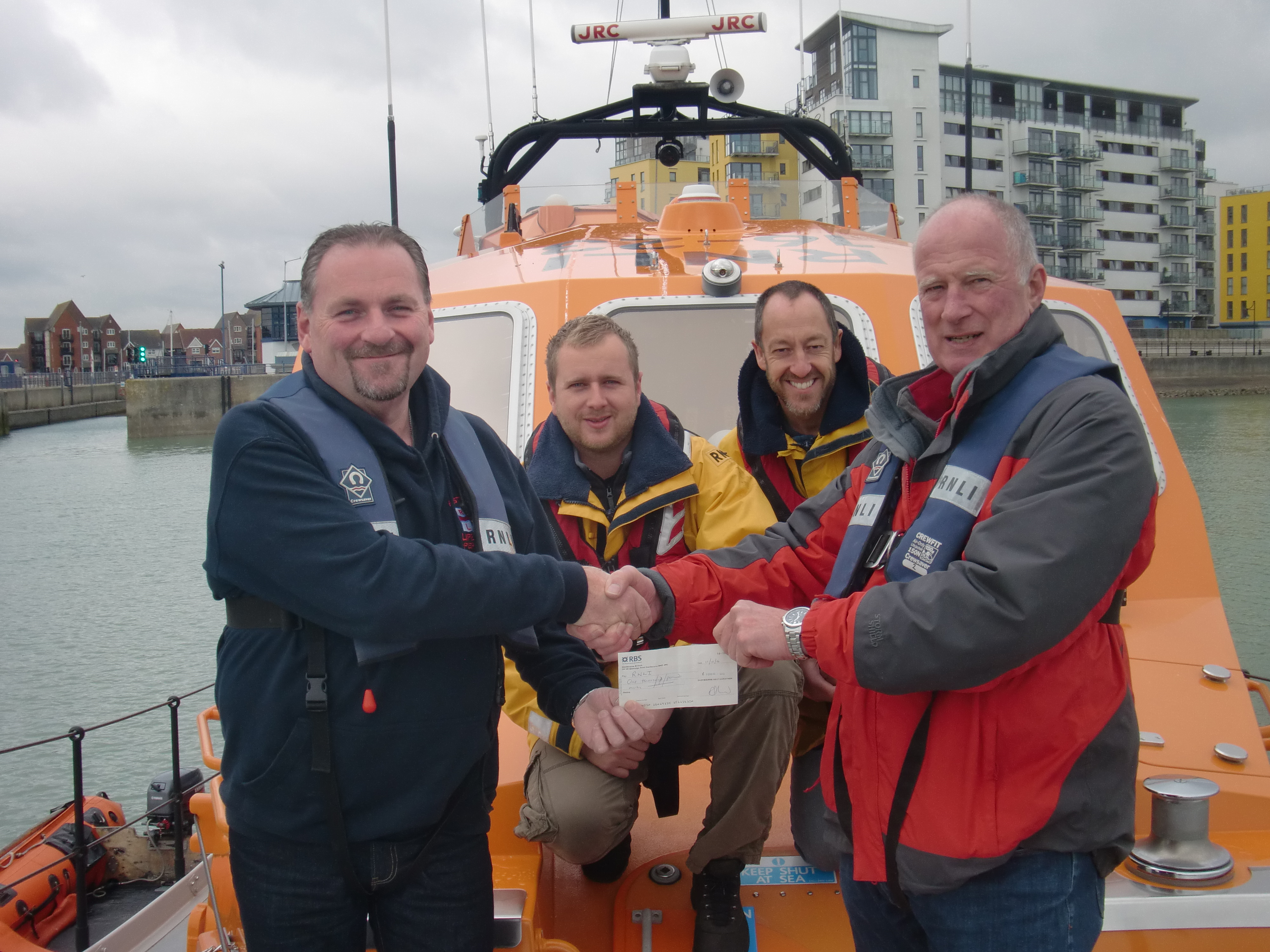 Mike Reid presents the cheque to Eastbourne RNLI