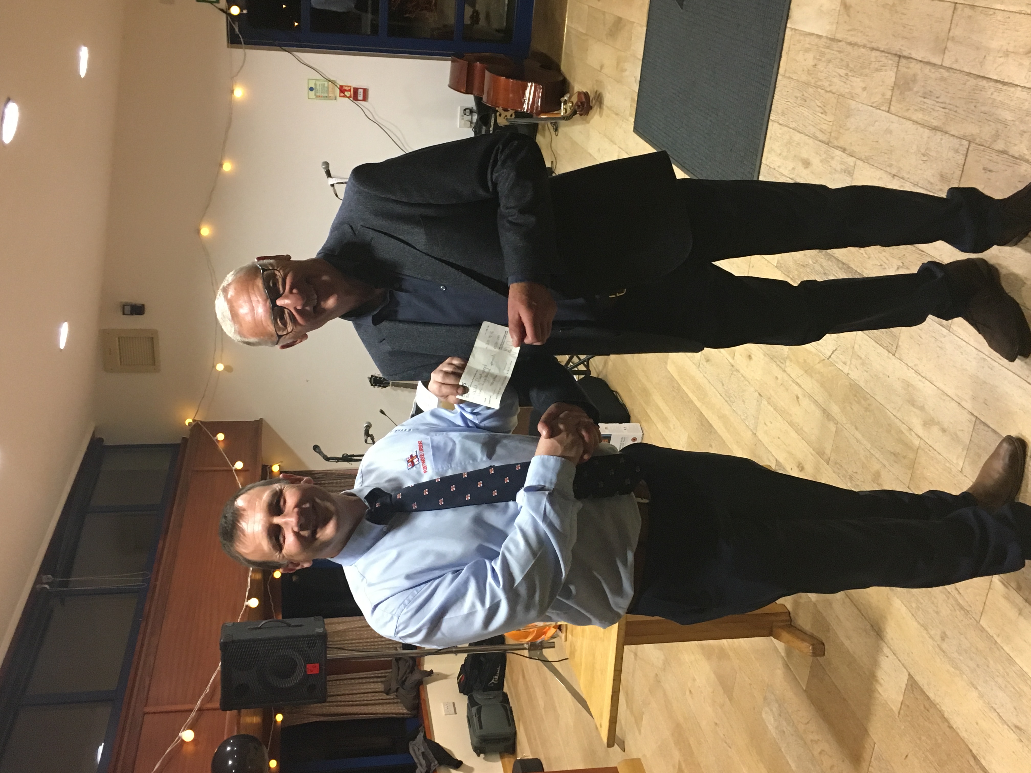 Coxswain Gary Randles receiving the cheque from John Spence