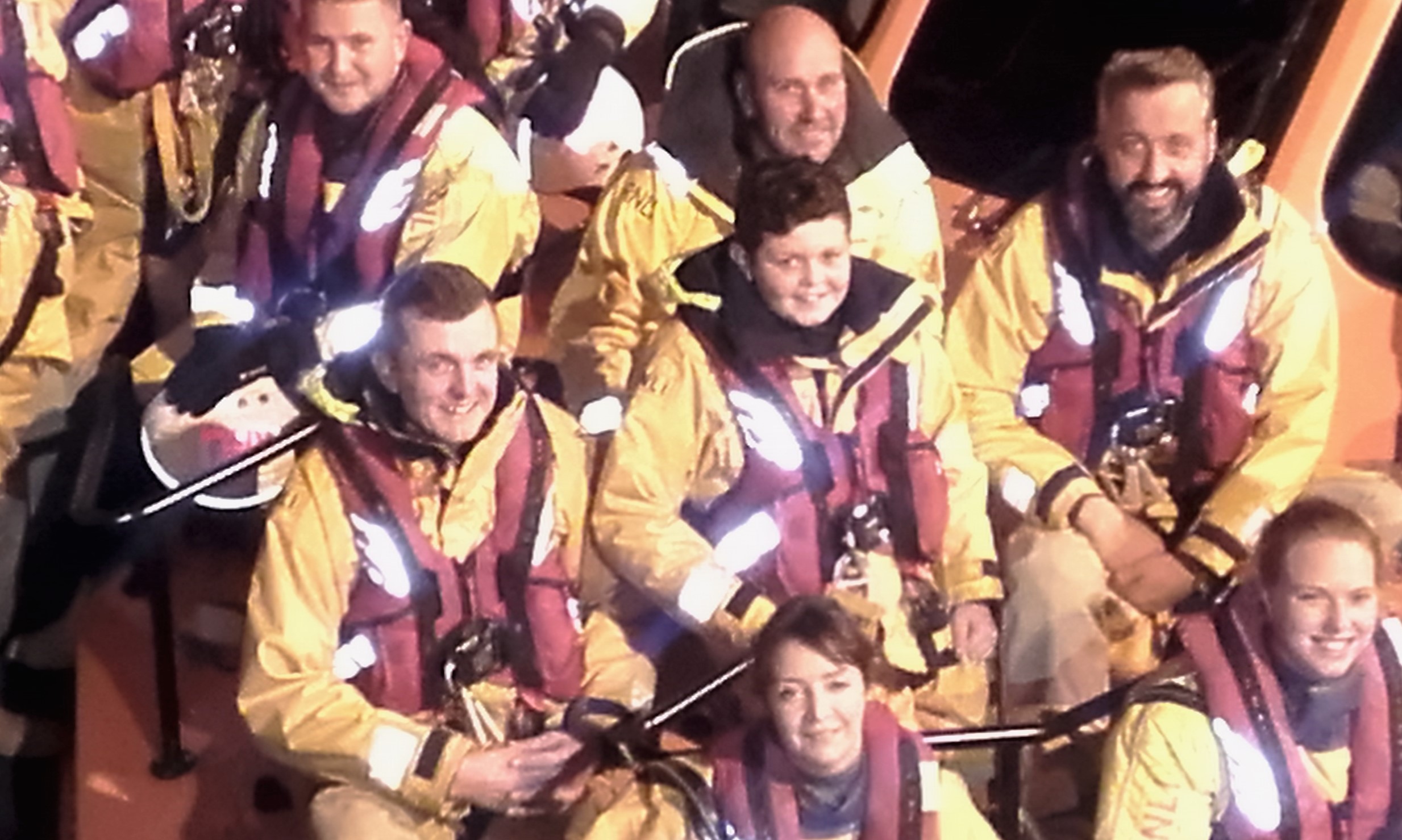 Schoolboy Daniel is dressed in the traditional yellow waterproof clothing, along with the rest of the lifeboat crew.