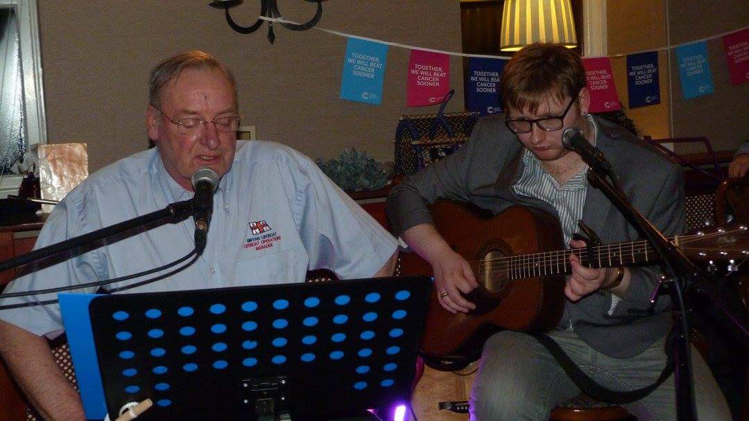 Lifeboat Operations Manager John Gourlay singing accompanied by event organiser and son JP Gourlay on guitar