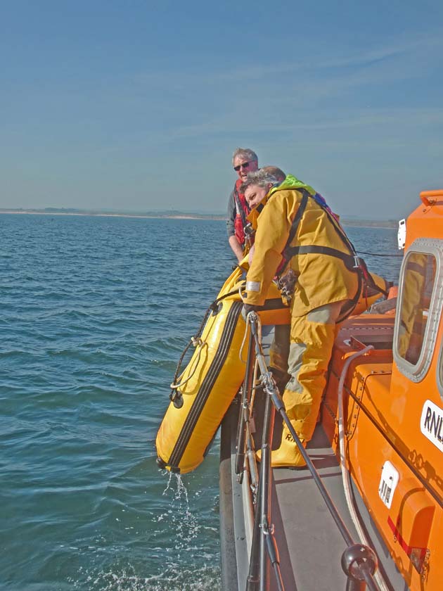 Damaged tendered being pulled aboard Lifeboat