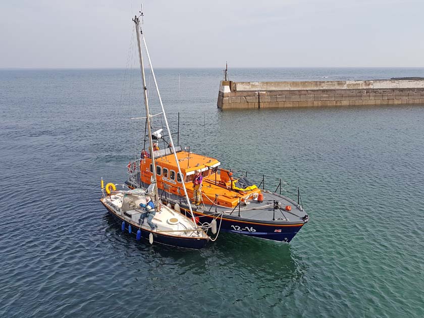 Yacht under alongside tow at Harbour entrance