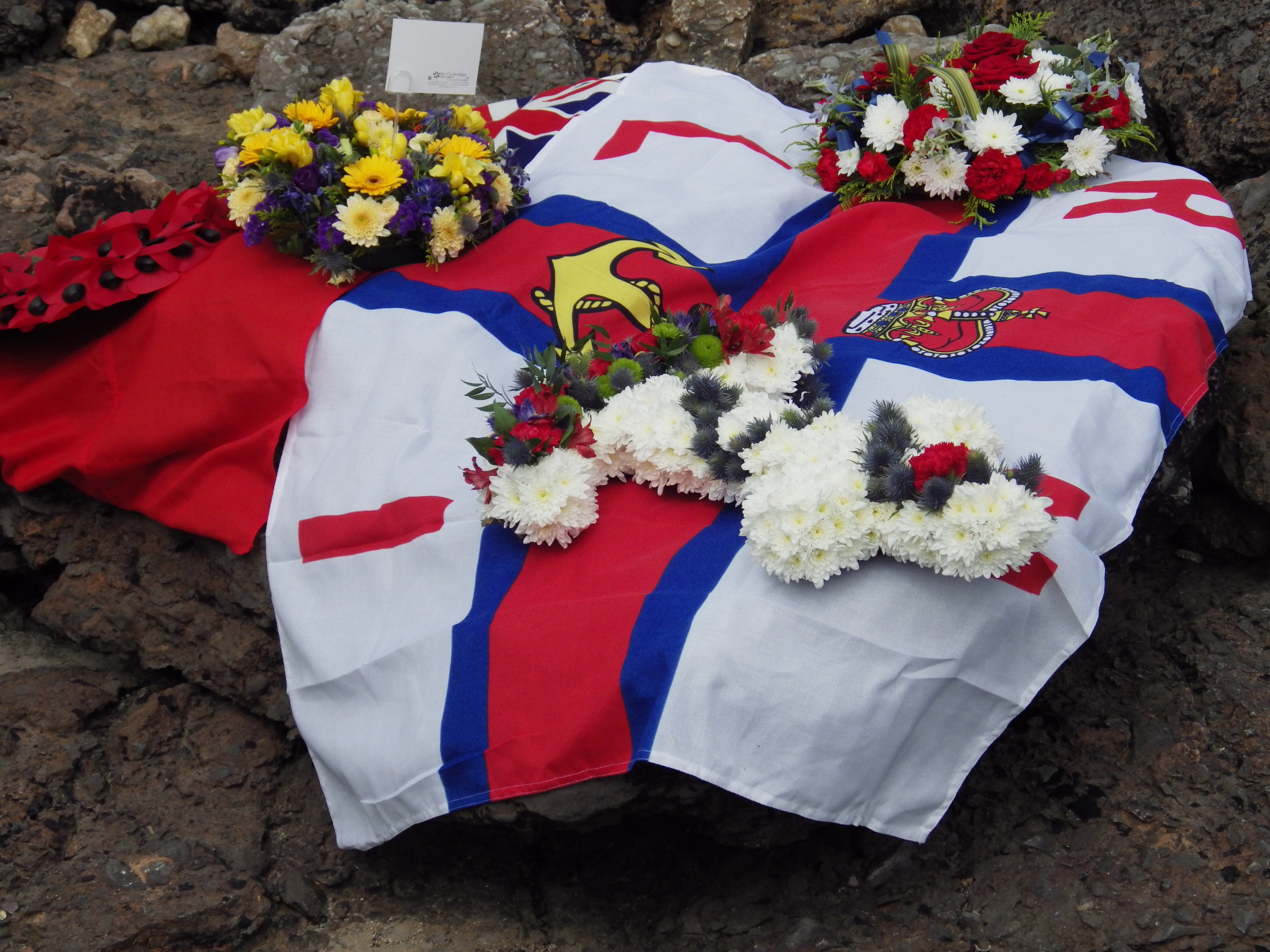 Flags drape the rocks next to the memorial plaque
