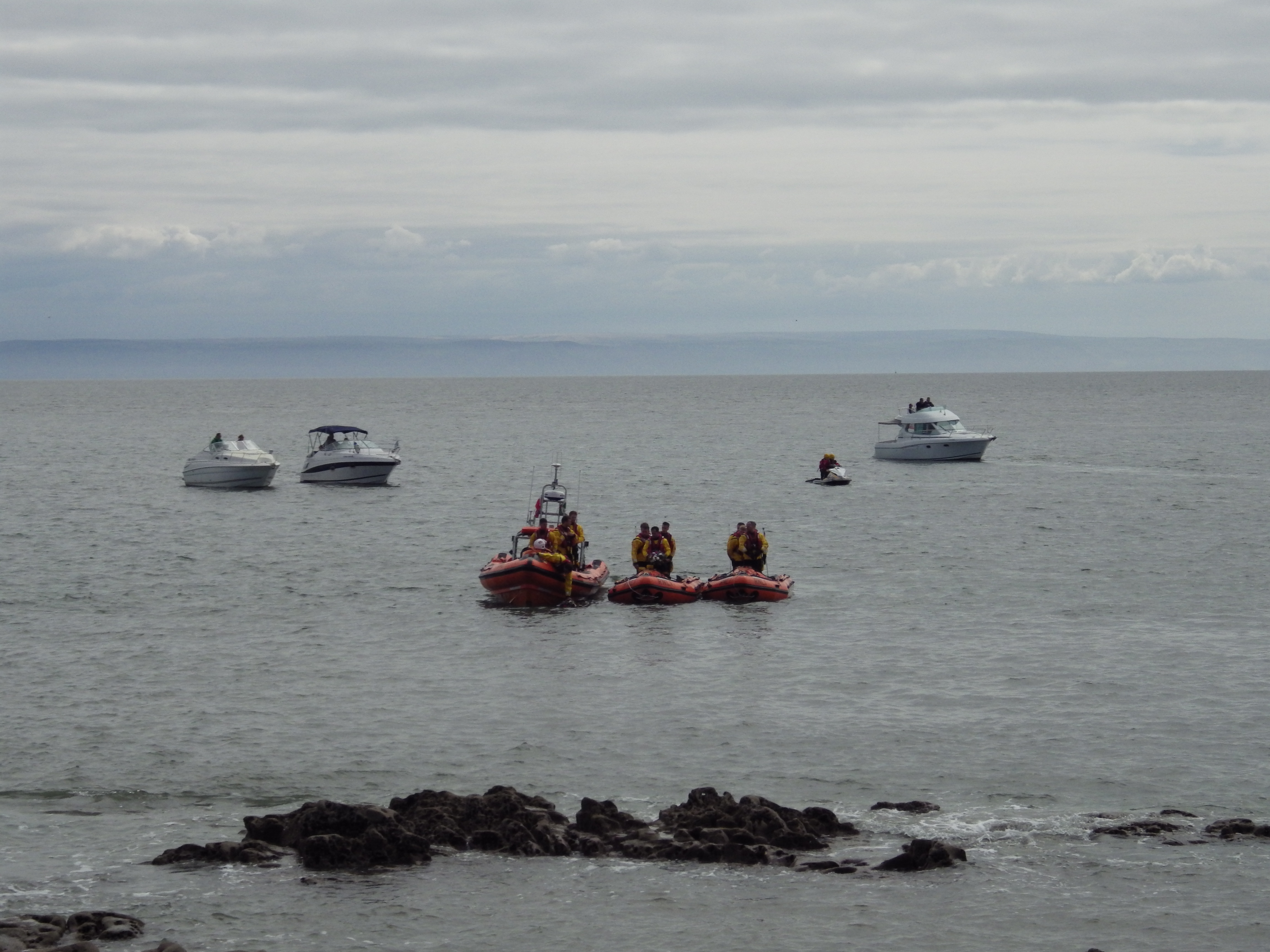 Crew stand in memory as they lay wreaths at Sker Point.