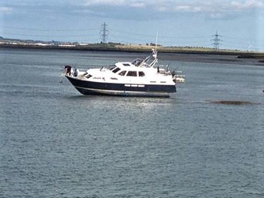 The cabin cruiser hard aground in the medway estuary faces a long wait for the tide to turn and get the craft refloated