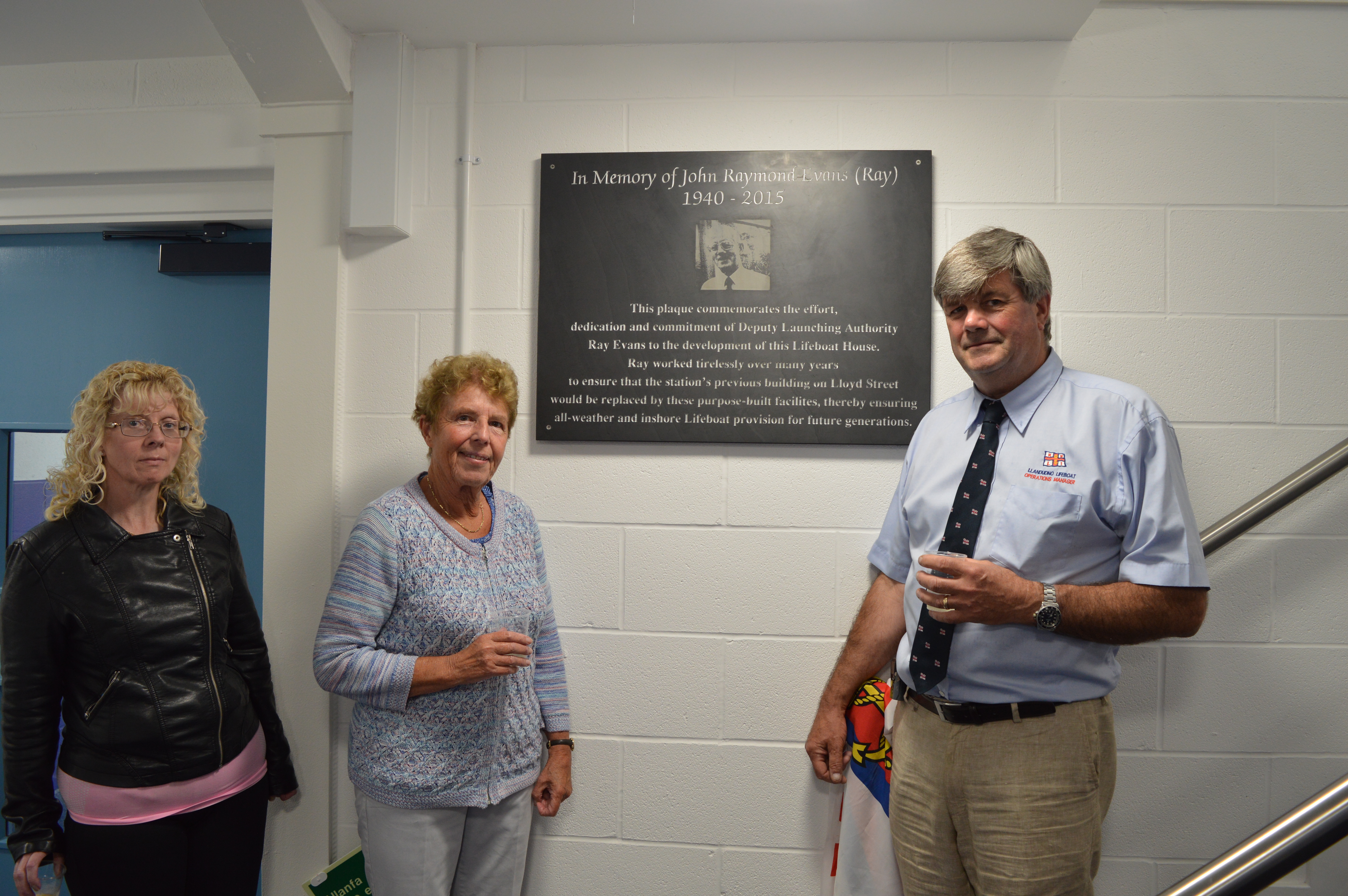 The plaque is unveiled by Ray's widow Mrs Jenny Evans accompanied by their daughter Joanne and watched by Llandudno Lifeboat Operations Manager Capt Marcus Elliot.