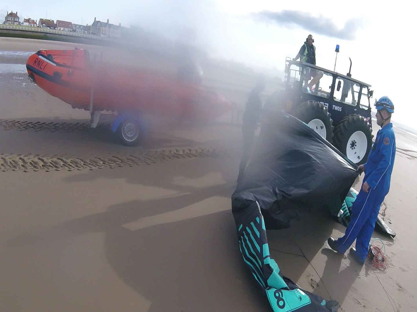 coastguards and lifeboat crew assist kite surfer