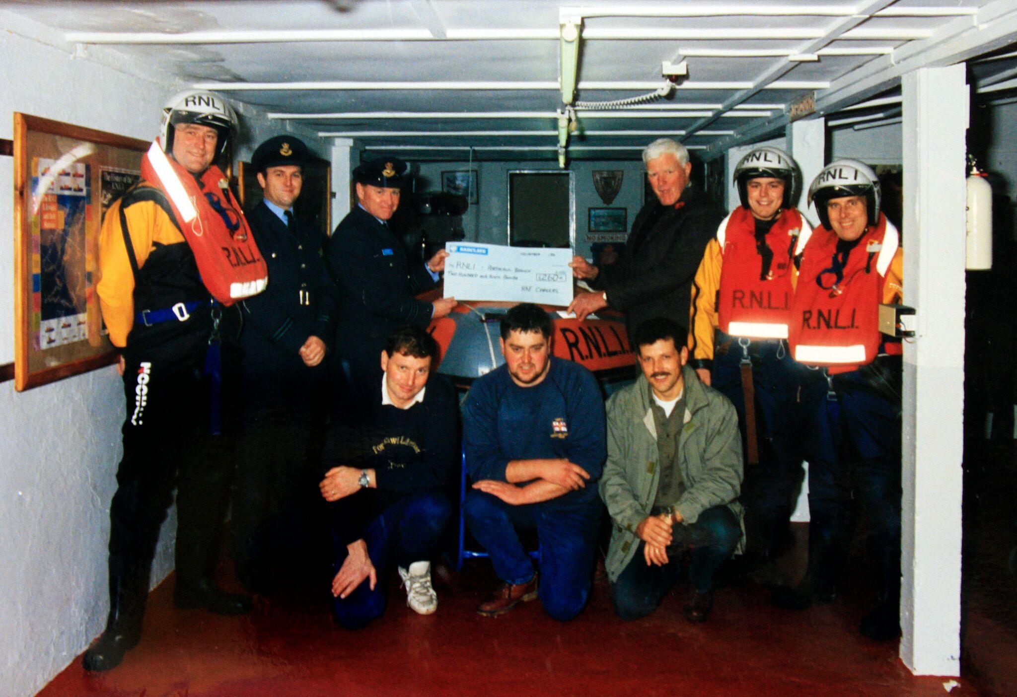 Picture is dated approx 1990 at the 'old station'. RAF officers present John with a cheque also pictured are six Porthcawl crew