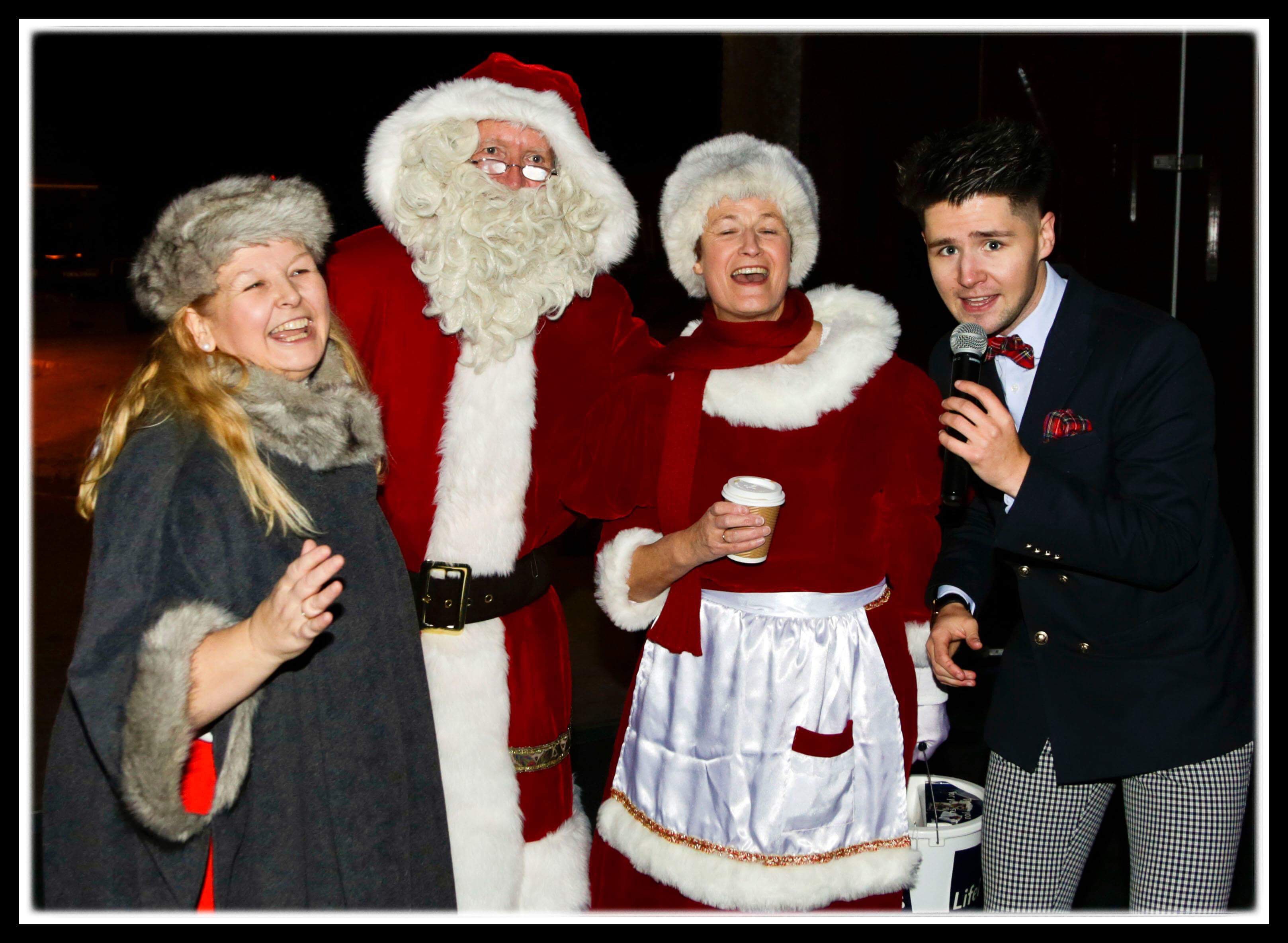 Russell Jones of X Factor fame singing with Santa and Mother Christmas, (left) Russell is supported by his own mother.
