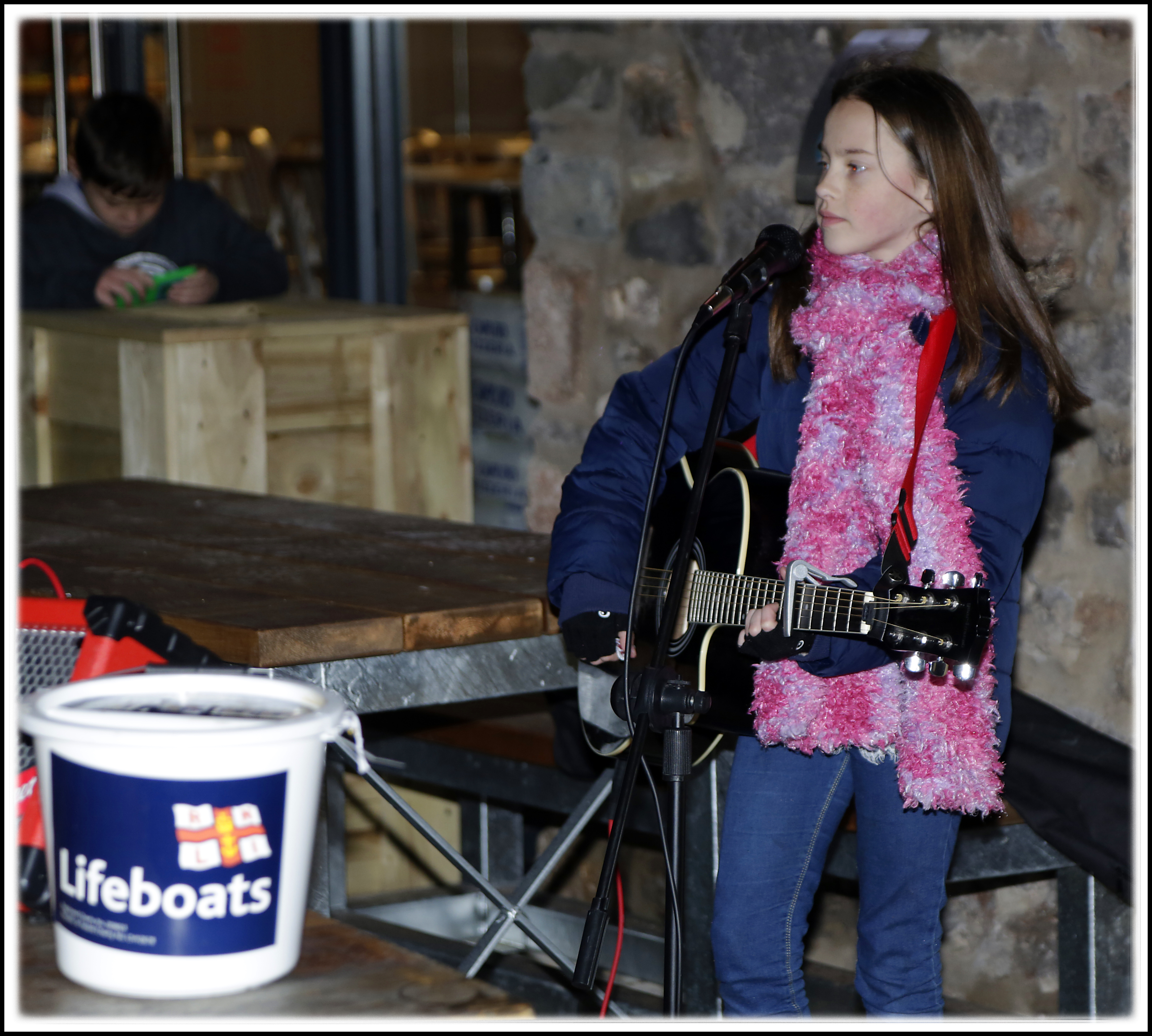 Taya sings to entertain the public waiting to see Santa 