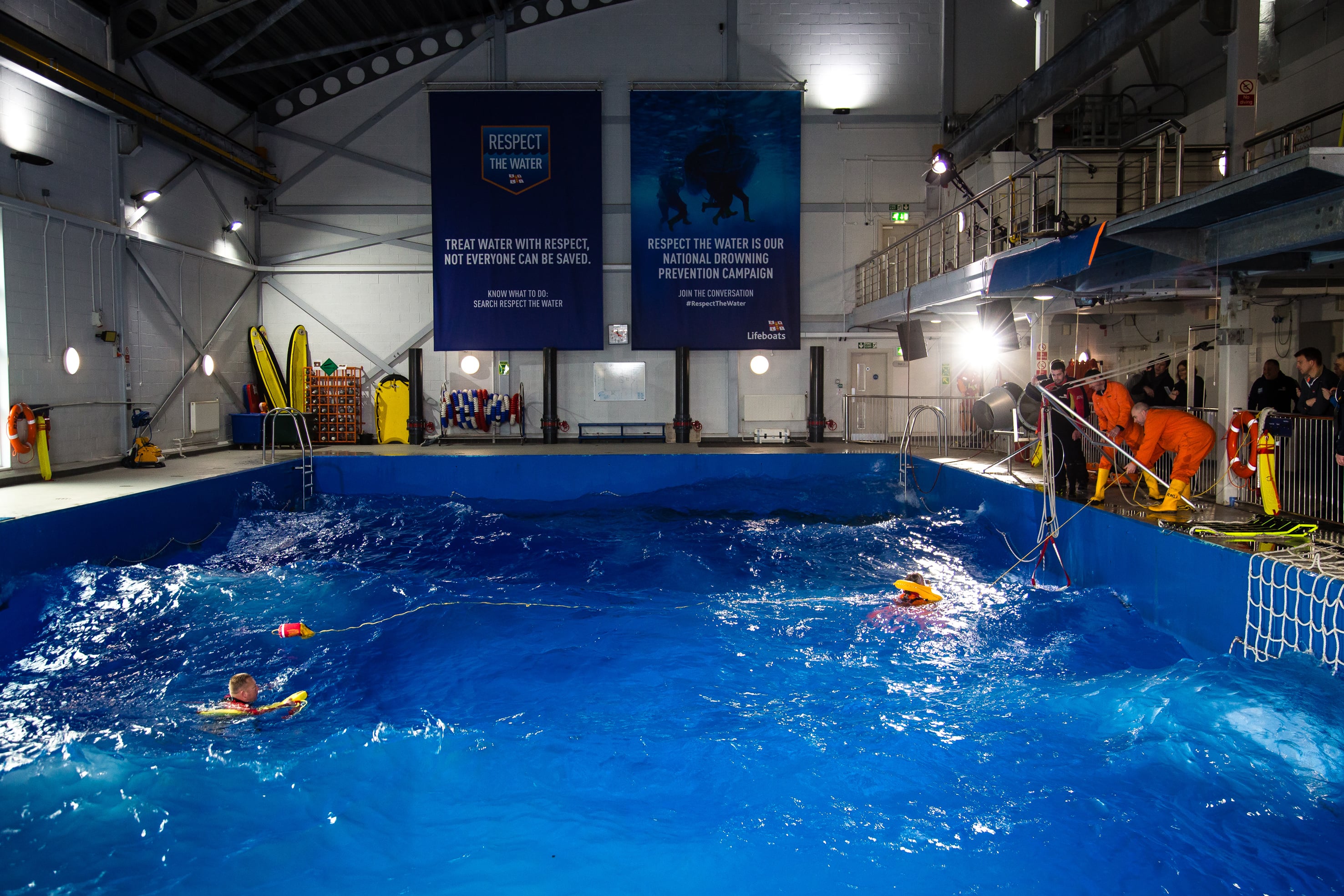 A fisherman is being pulled from the water during a safety exercise underway in the RNLI's sea survival pool