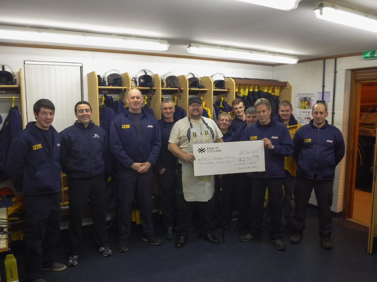 Calum Mackinnon from Ye Corporation of Squaremen presenting a cheque to the volunteer crew at RNLI Macduff