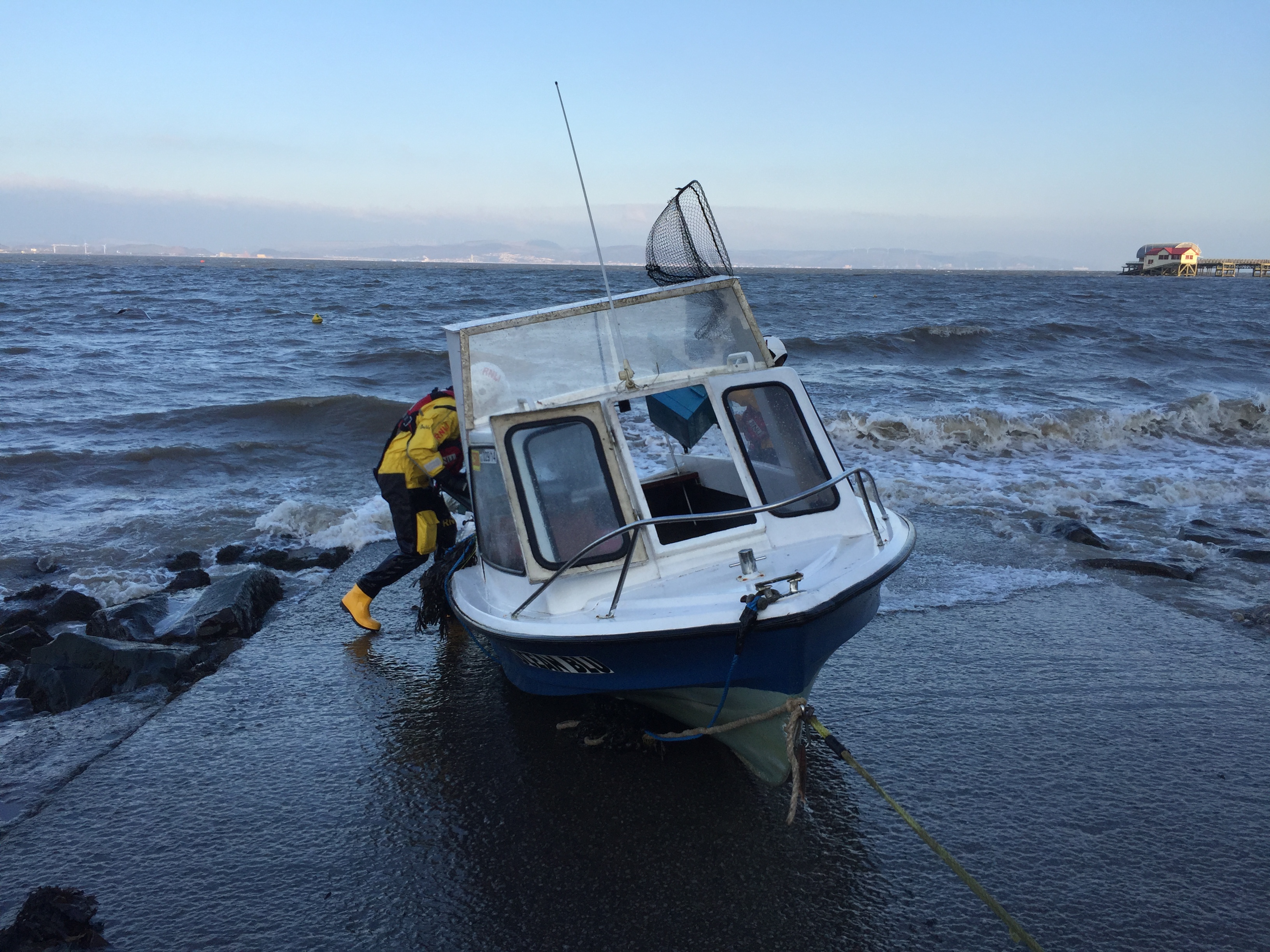The fishing boat was emptied of more water before the making tide flooded it again