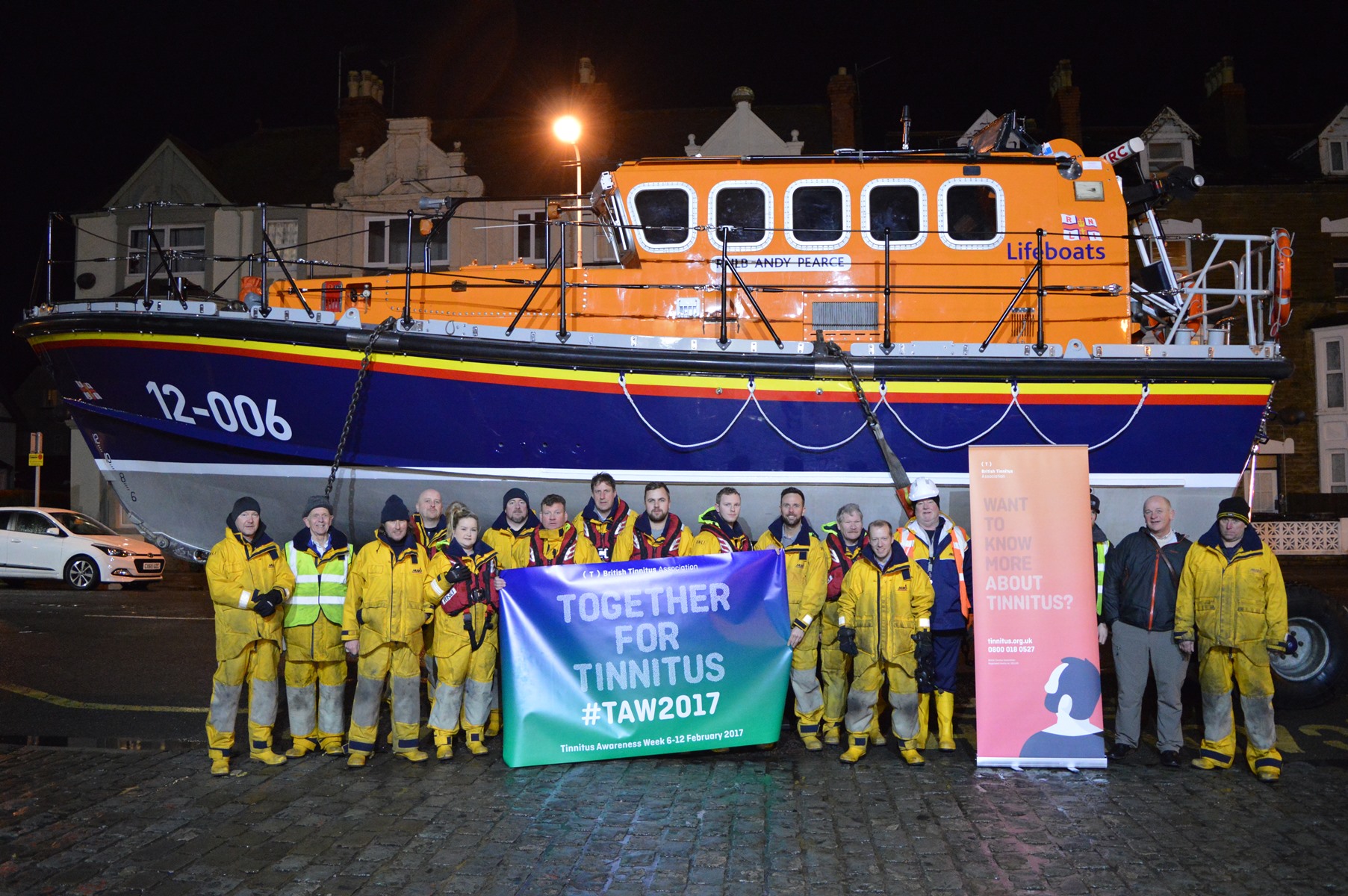 Llandudno RNLI volunteers in front of their all-weather lifeboat Andy Pearce to raise awareness for Tinnitus Awareness Week