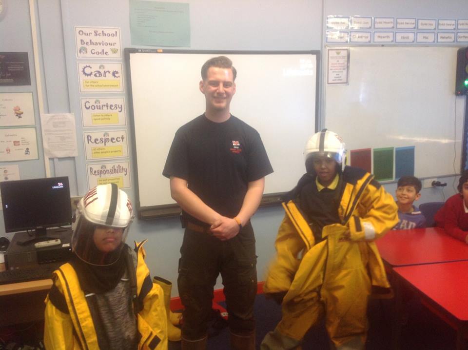 Mount Stuart Primary School pupils Hussein and Ola trying on lifeboat kit with Barry Dock RNLI Education Officer Ben Phillips