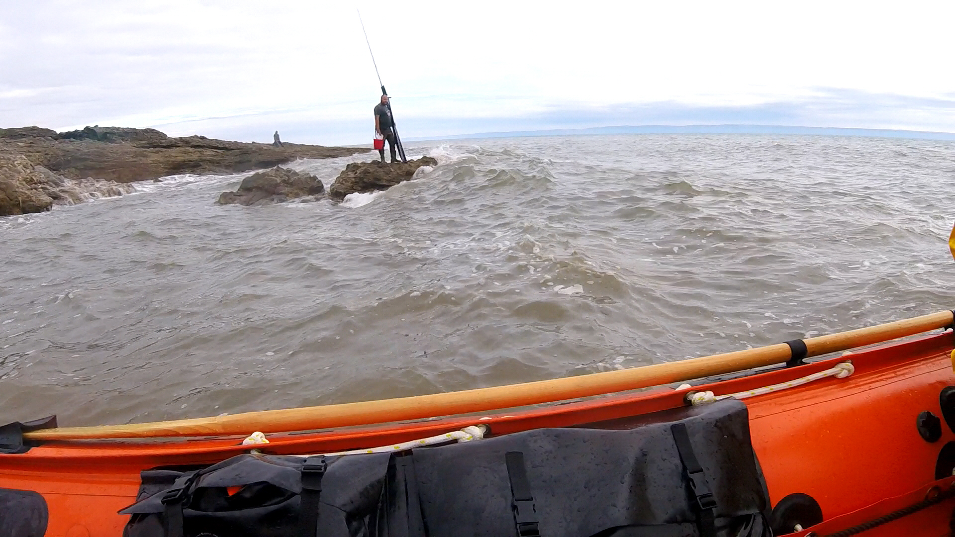 Fisherman within minutes of the rising tide covering the rocks.