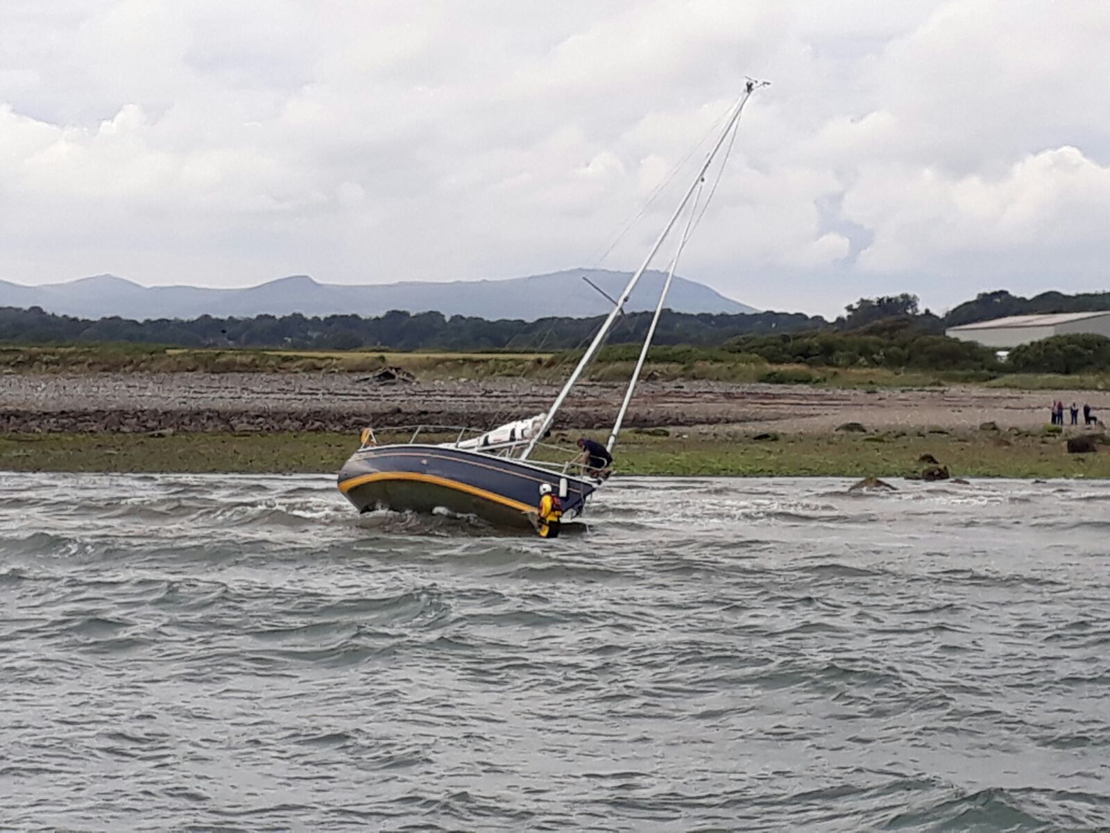 Crew Member form Pwllheli RNLI, assesing any damage to hull