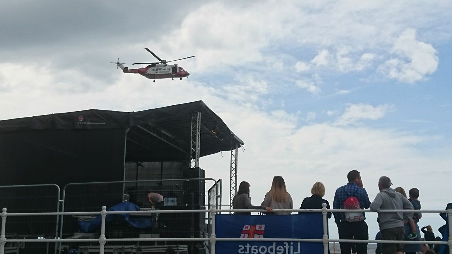 Coastguard Rescue Helicopter above the carnival band stage outside lifeboat station