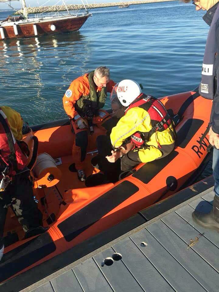 The helicopter paramedic and a lifeboat crew member tend to the yachtsman prior to his transfer to a waiting ambulance.
