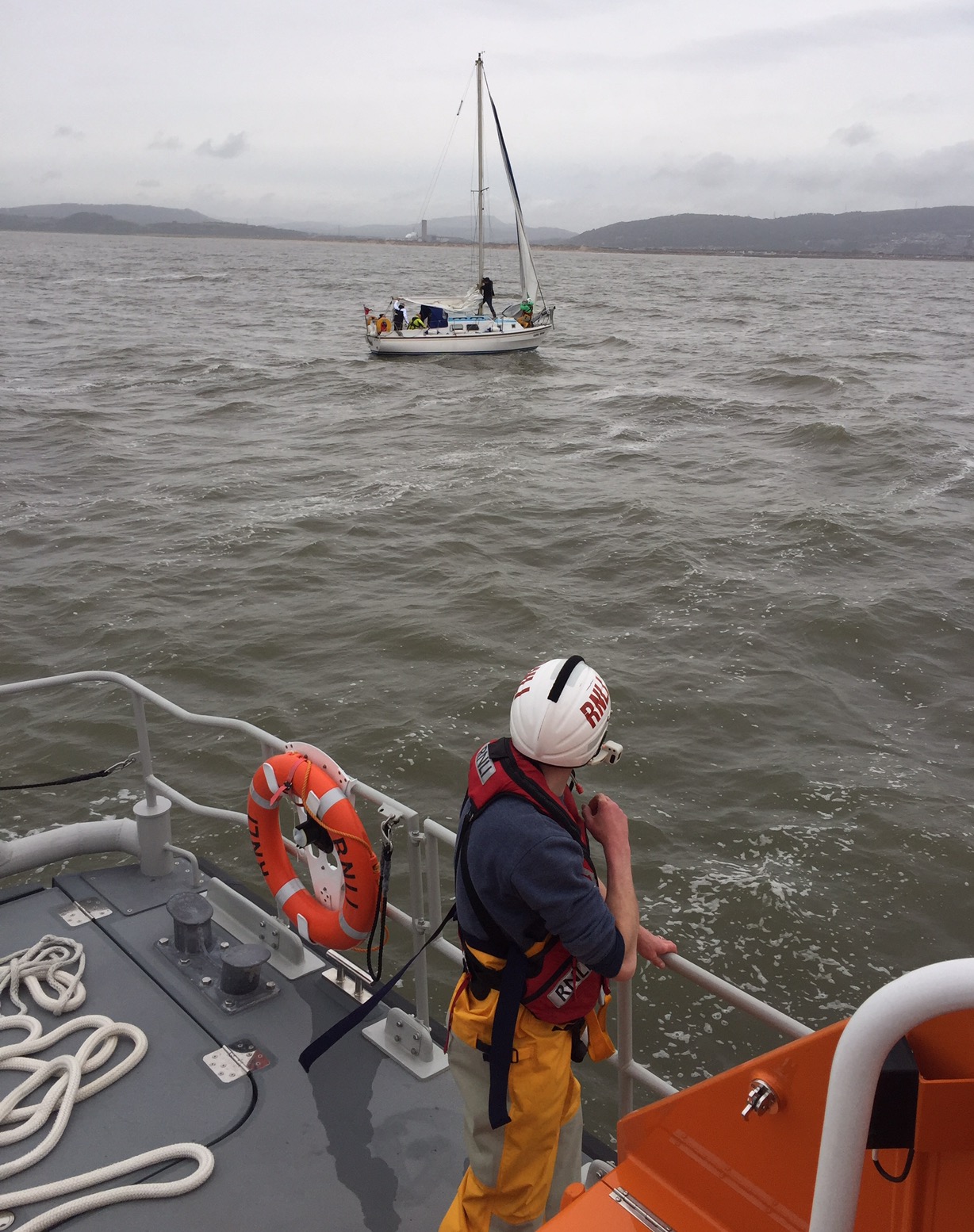 Crew prepare to tow yacht