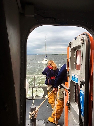 Trent class all weather lifeboat returning to troon with the casualty yacht being towed to the stern
