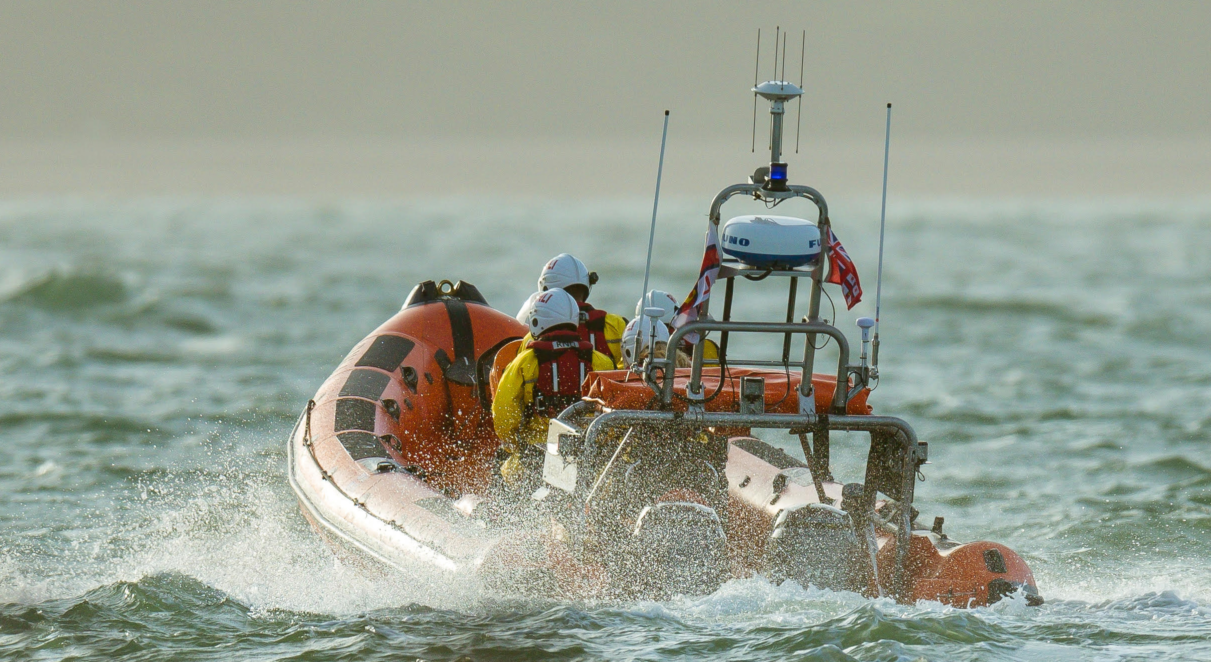 Cowes lifeboat races through the choppy sea to the capsized windsurfer.