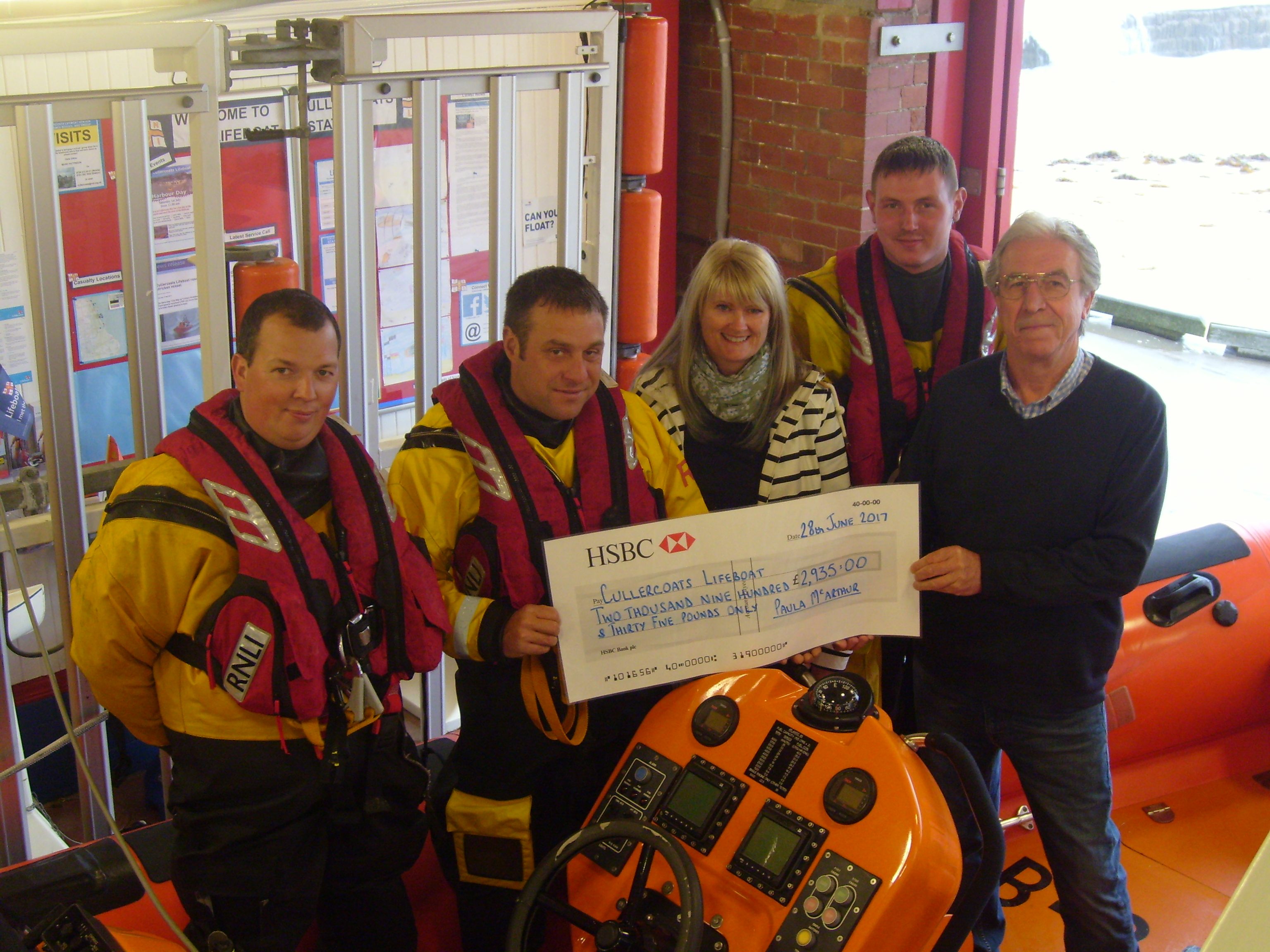 Paula presenting cheque to crew and Operations Manager
