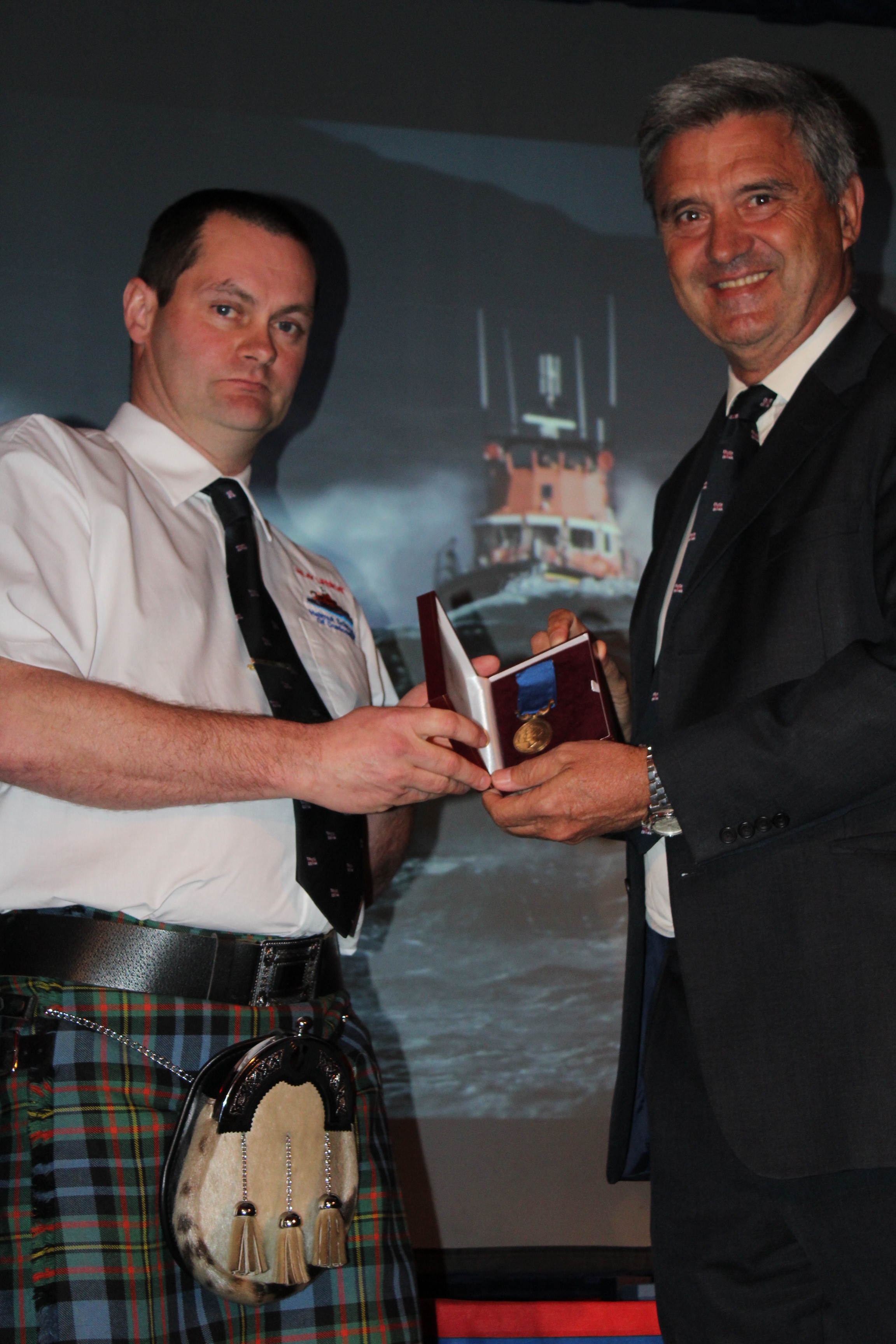 Islay Coxswain David MacLellan receives the Bronze Medal from RNLI Chief Executive Paul Boissier
