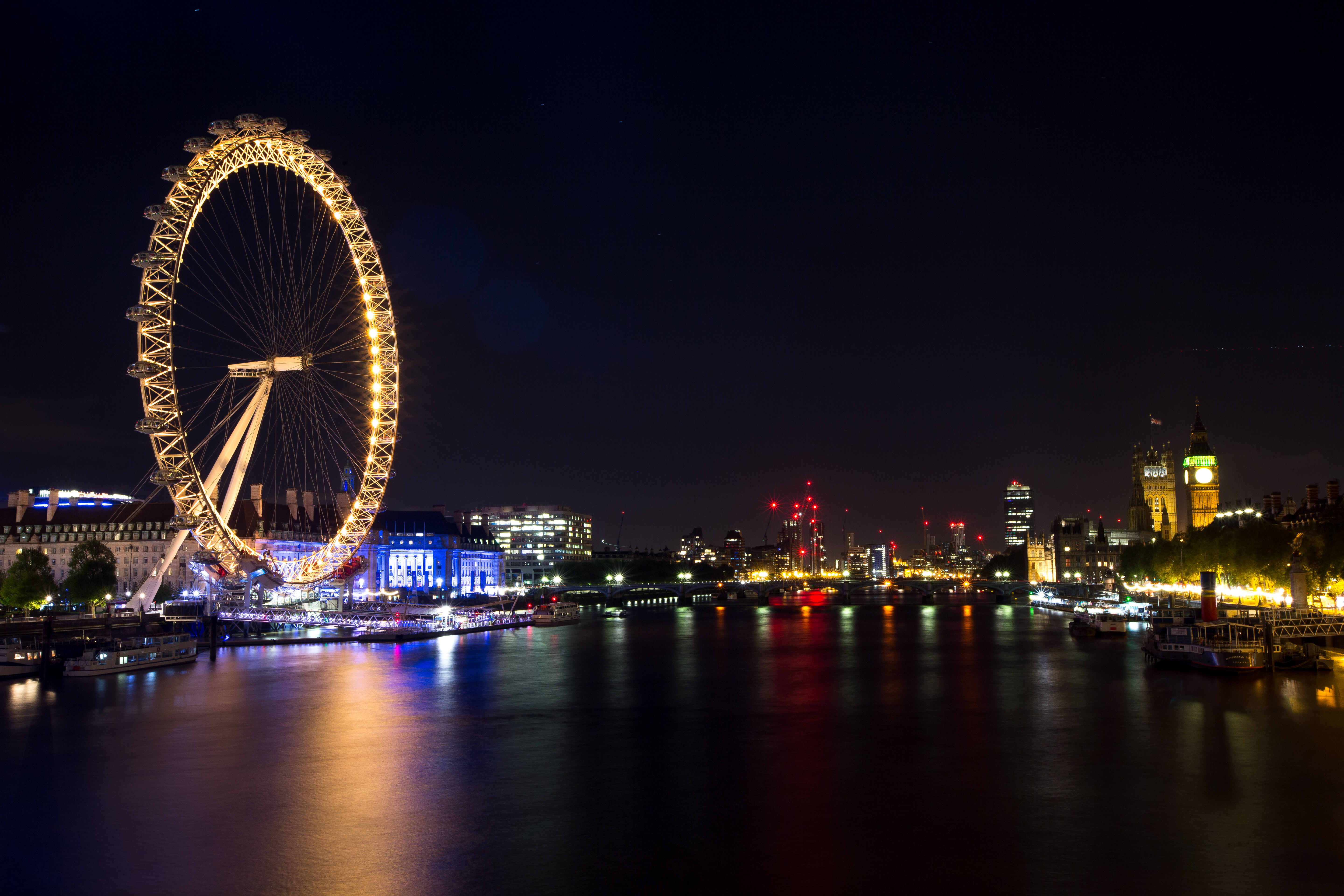 The Coca-Cola London Eye shines yellow in the London night sky