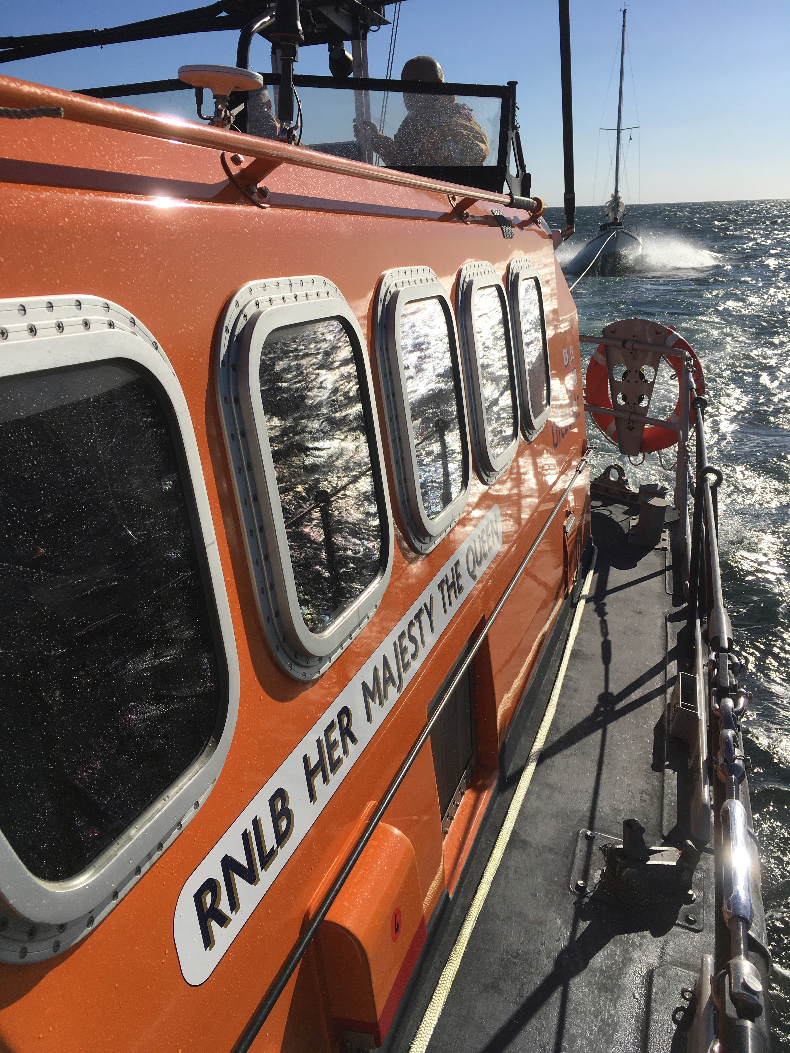 The Lifeboat with the yacht visible on the end of the tow line astern