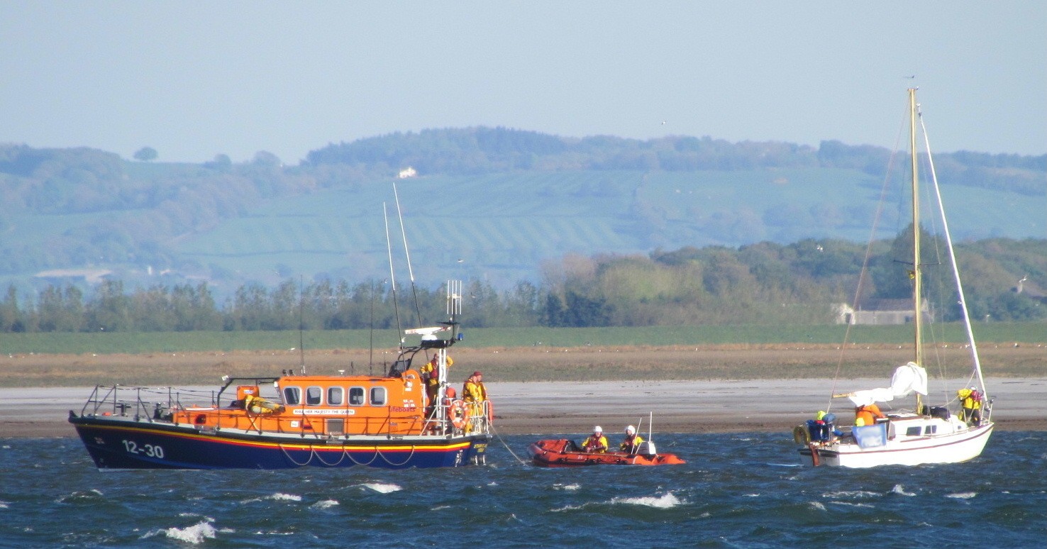 The Lifeboat has stopped and is about to pass the tow over to the Lytham Inshore Lifeboat (centre) with the yaccht to the right.
