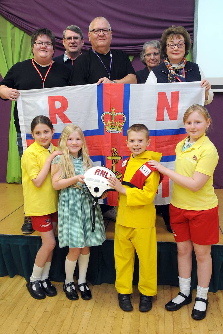 Members of Rita Cole’s family, along with pupils from the Woodlands Academy of Learning, present £200 to the RNLI in memory of Mrs Cole