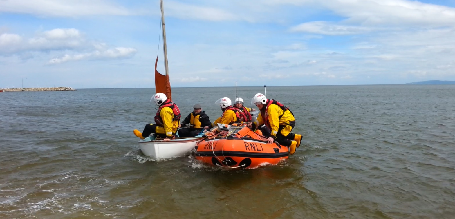 Brought to safety: Llandudno lifeboat brings dinghy and occupants into Rhos-on-Sea slipway.