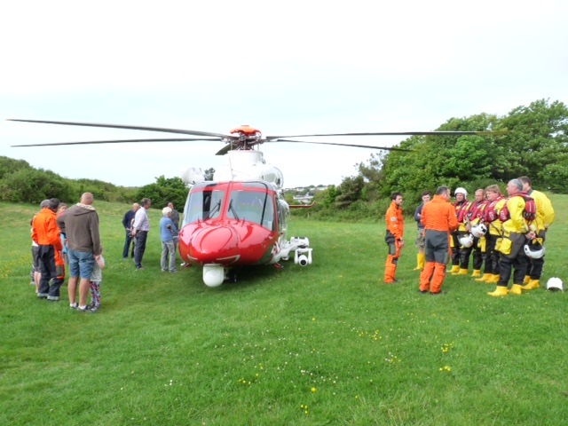 The Horton and Port Eynon RNLI lifeboat crew receiving a breifing from the Coastguard Search and Rescue Helicopter crew on the village green