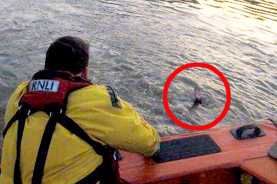 The man's hand is all that can be seen as the RNLI lifeboat approaches