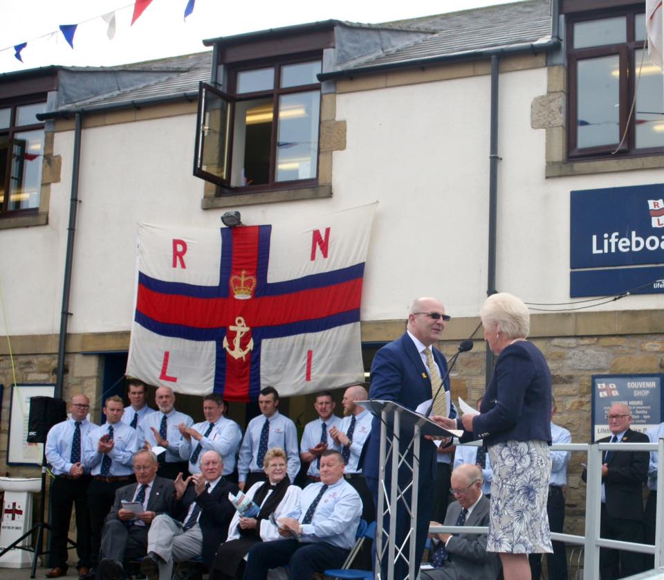 Diane Loveridge formally handing over lifeboat to RNLI with Robbie Warrington accepting