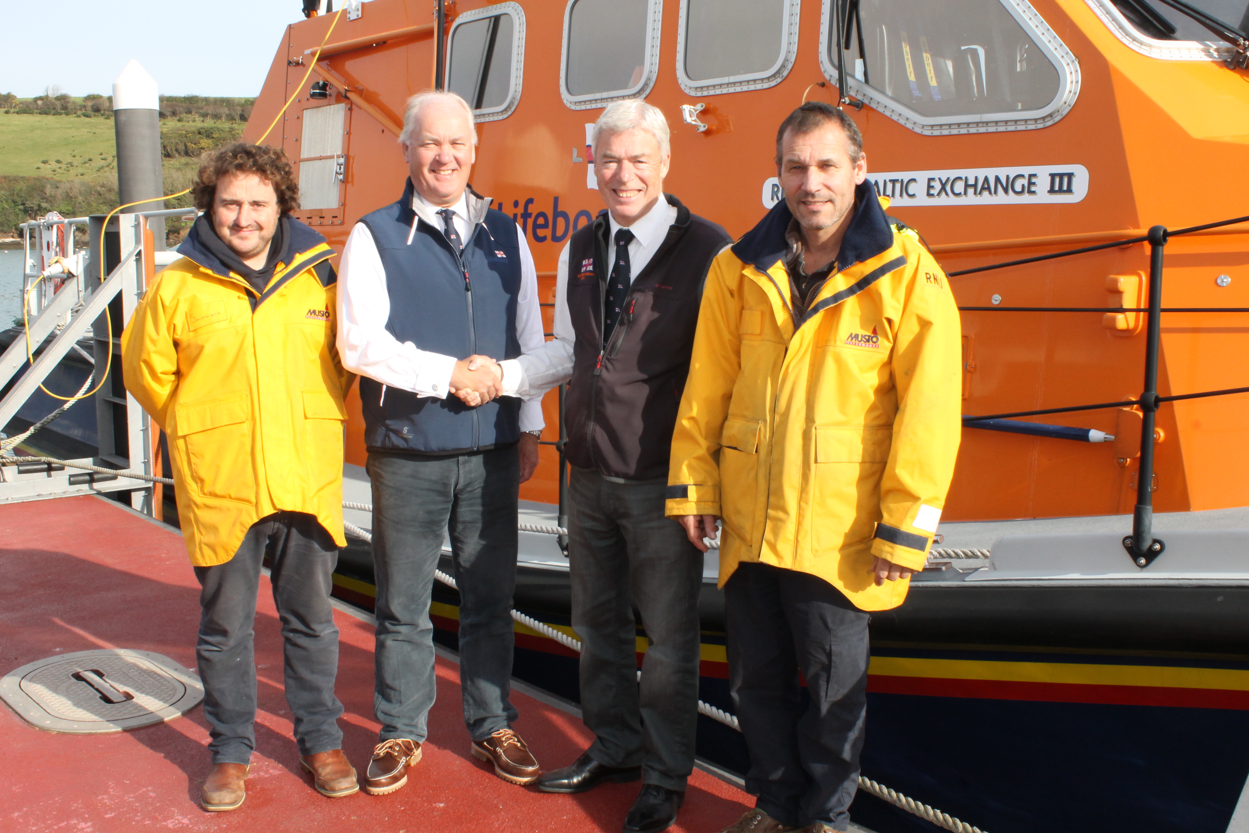 Simon Evans passing on duties to Mark Dowie with Coxswain Chris Winzar and Mechanic Sam Viles in attendance