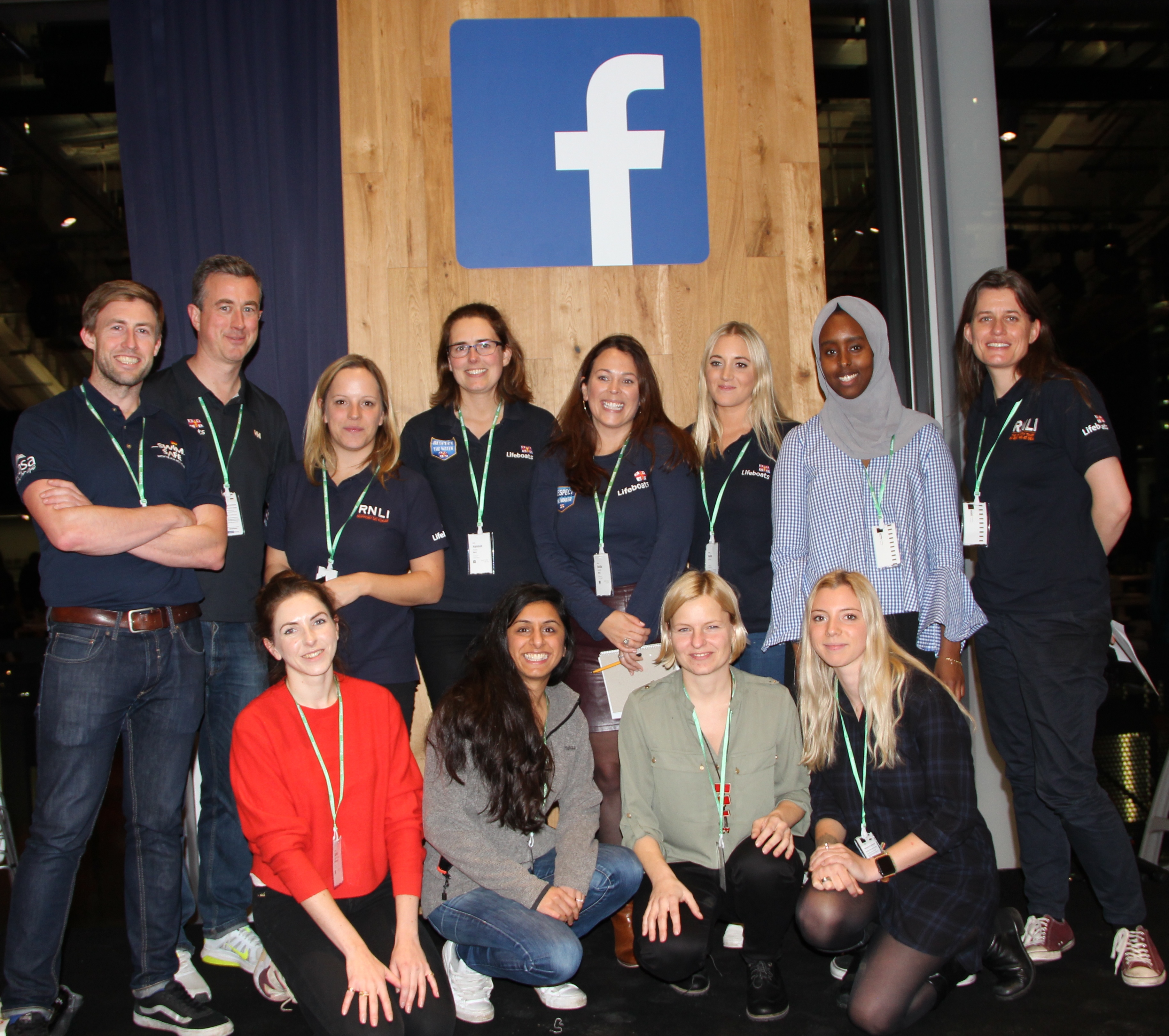 Members of the winning hackathon team with RNLI staff smile in front of a Facebook logo