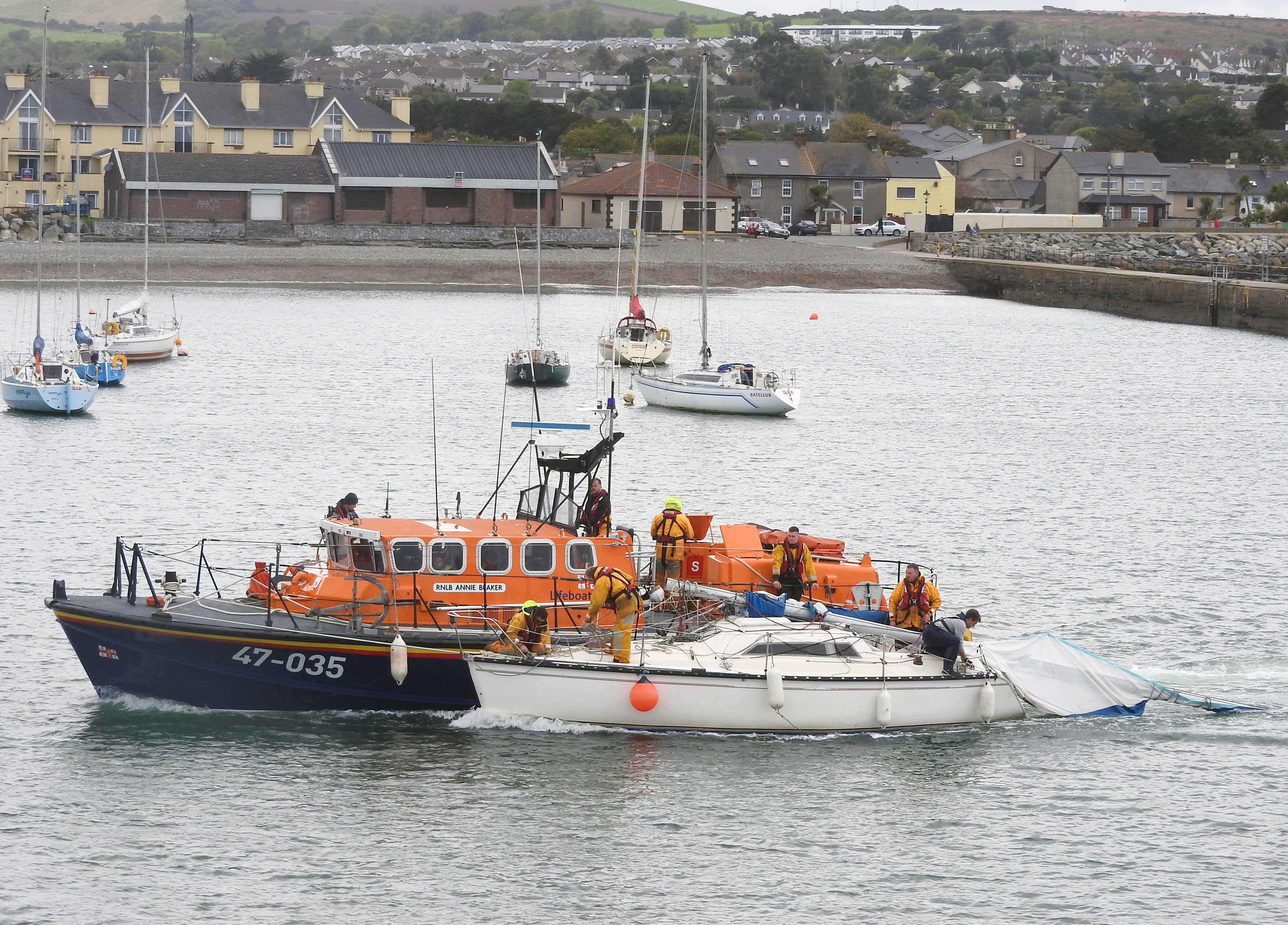 Wicklow RNLI all-weather lifeboat with the dismasted yacht at Wicklow harbour