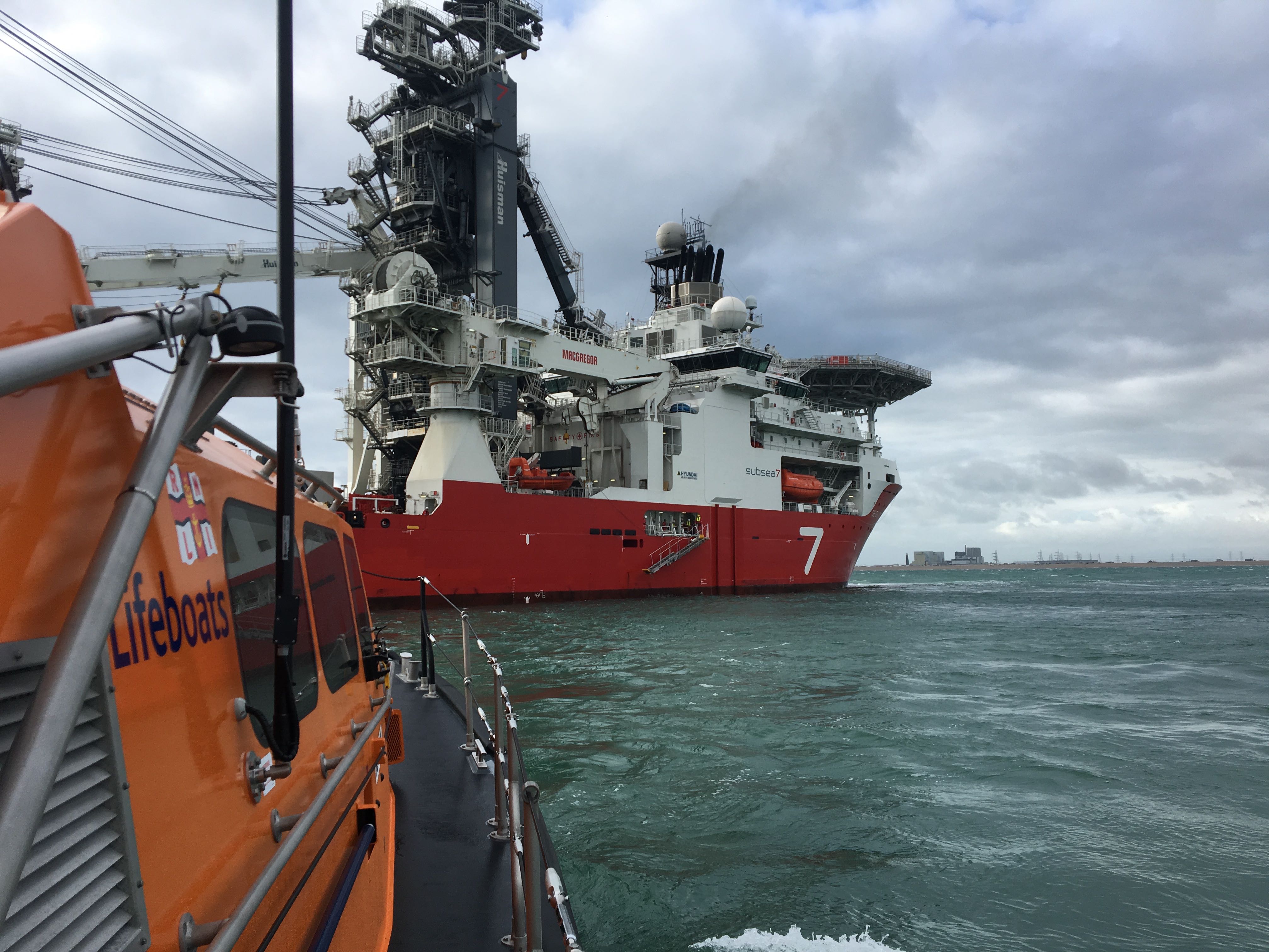 RNLI lifeboat goes along side the survey vessel to take off injured crewman.