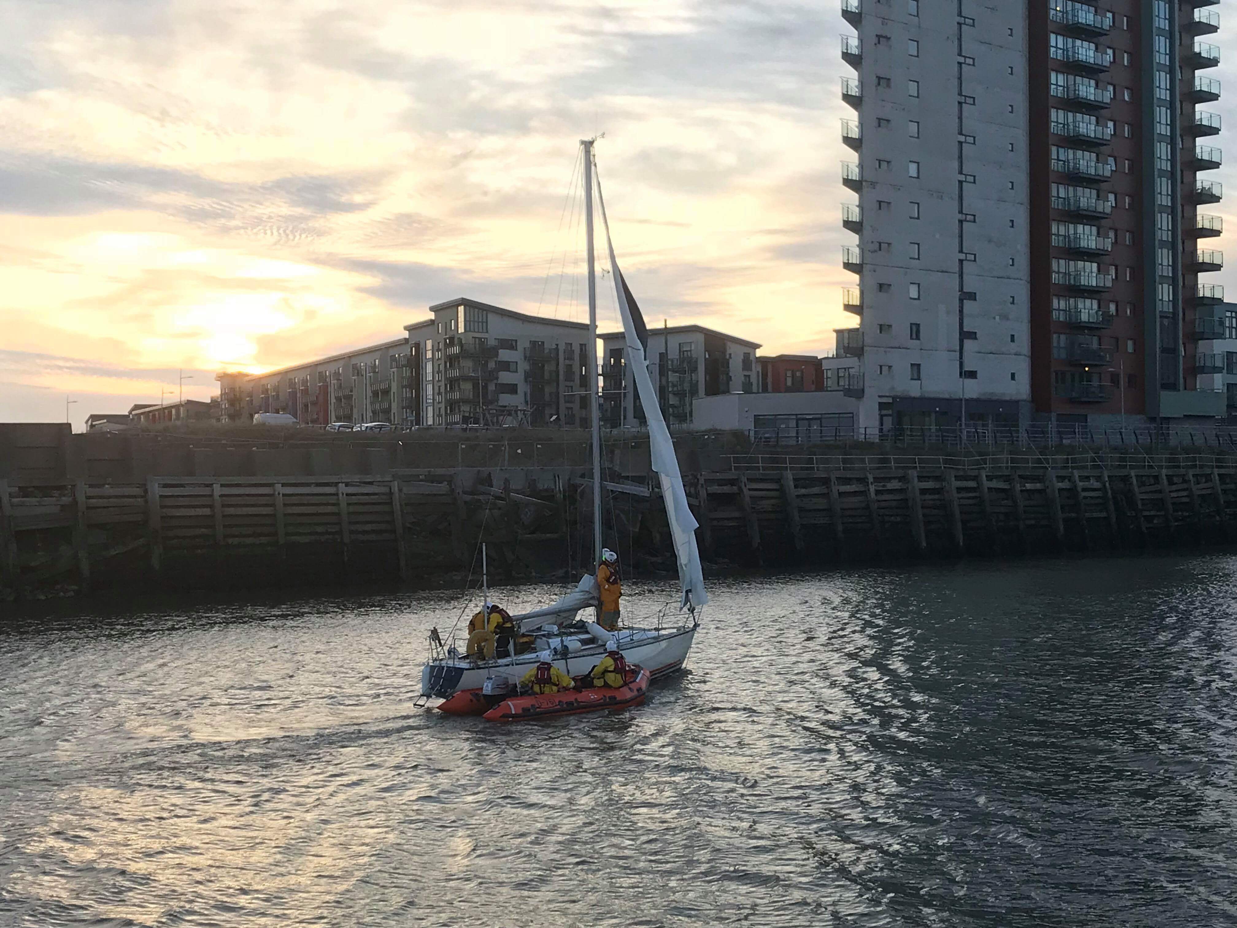 32 ft yacht being towed into the marina with the inshore lifeboat Mark Lott after being towed to the river by the All Weather Lifeboat