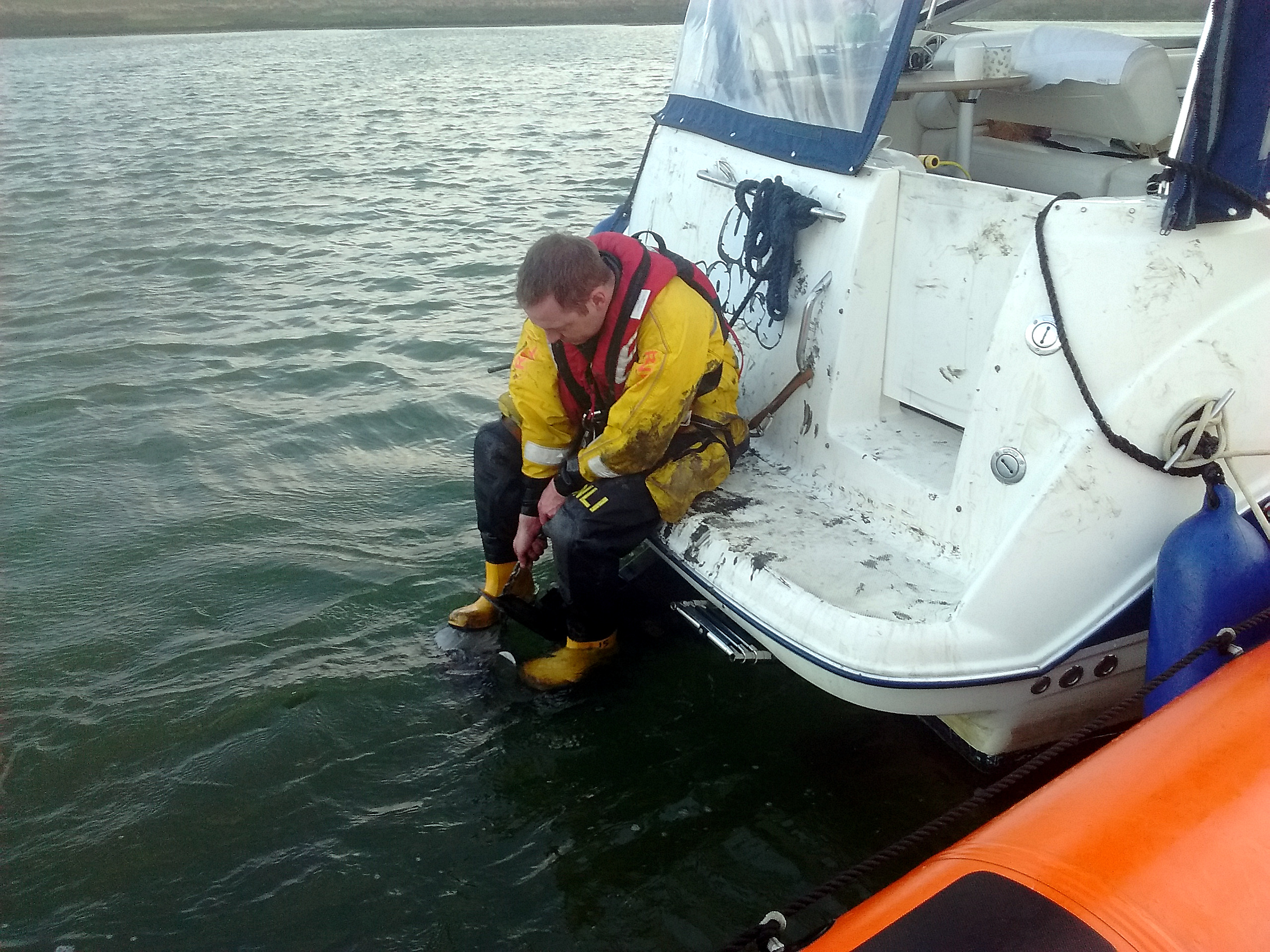 Lifeboat crewmember Ben Croswell begins the task of freeing the anchor chain from around the drive shaft and propeller of a Bayliner motor cruiser off the entrance to Conyer Creek in TheSwale on Saturday evening. Picture: Dave Parry/RNLI Whitstable.