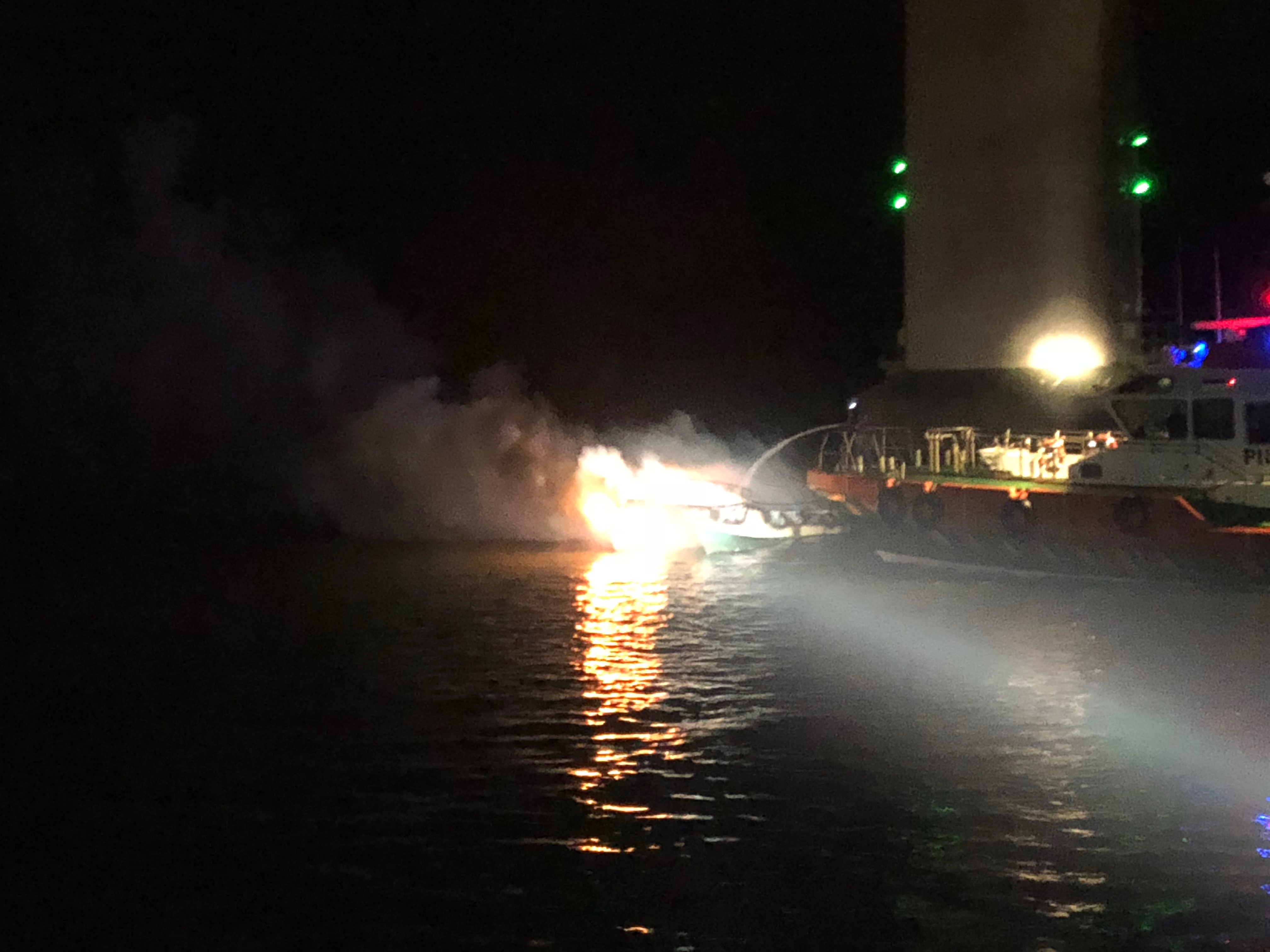 The searchlight from Angle RNLI’s all weather lifeboat illuminates the scene below the Cleddau Bridge as the Milford Haven Port Authority’s pilot boat fights the fire on board the fishing vessel.