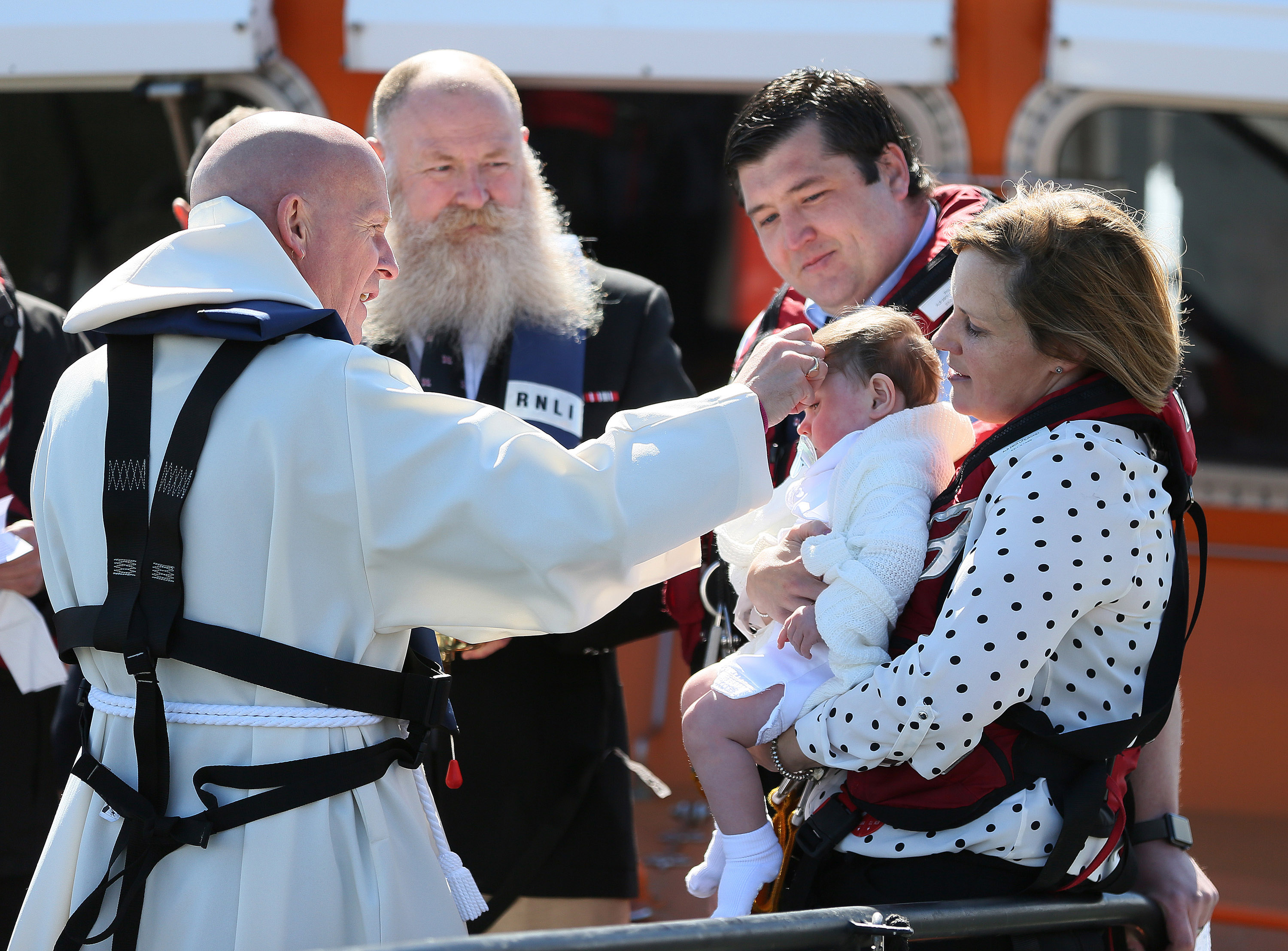 29 April 2018 RNLI Lifeboat christening - Harry Thomas Michael Brown is christened on board Tynemouth RNLI station's Severn class all weather lifeboat Spirit of Northumberland by Revd Canon Glyn Evans in front of proud parents Laura and Michael, the Godparents, family and friends, and Michael's fellow RNLI lifeboat crewmembers. Please credit Adrian Don/RNLI