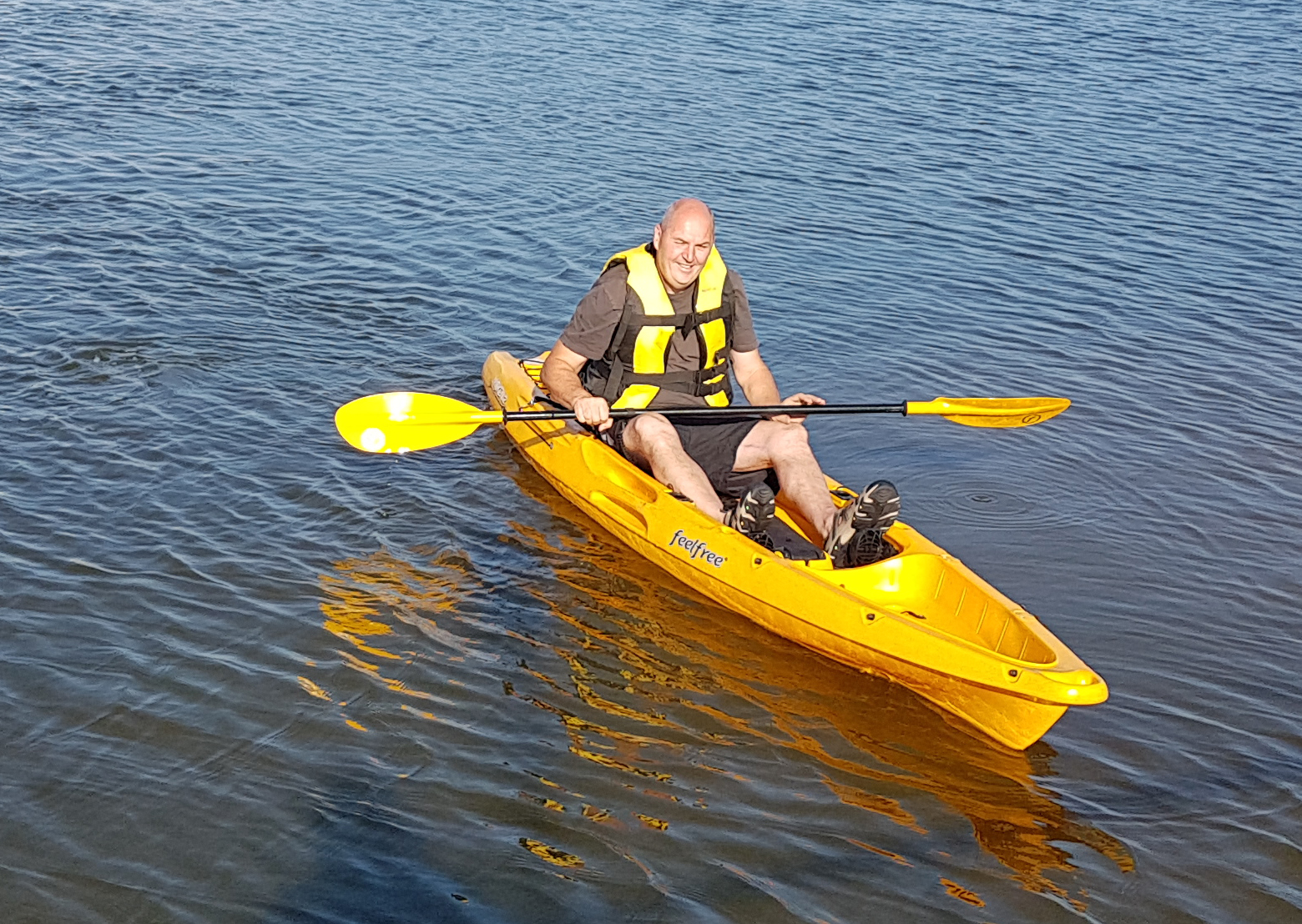 David sits in his yellow kayak with paddle up and surrounded by the water of Marine Lake on all sides