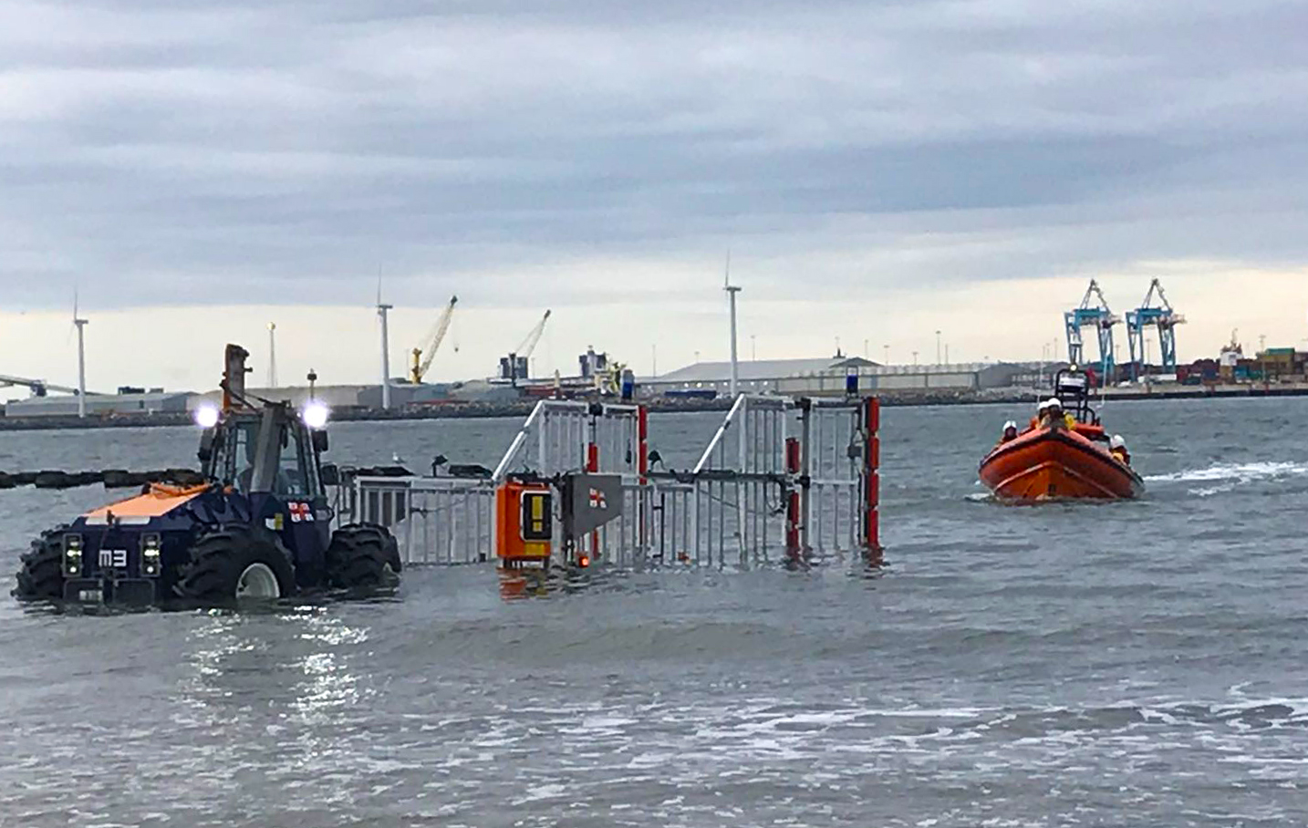 Tractor and empty trailer in the water awaiting the just-about-there RNLI lifeboat