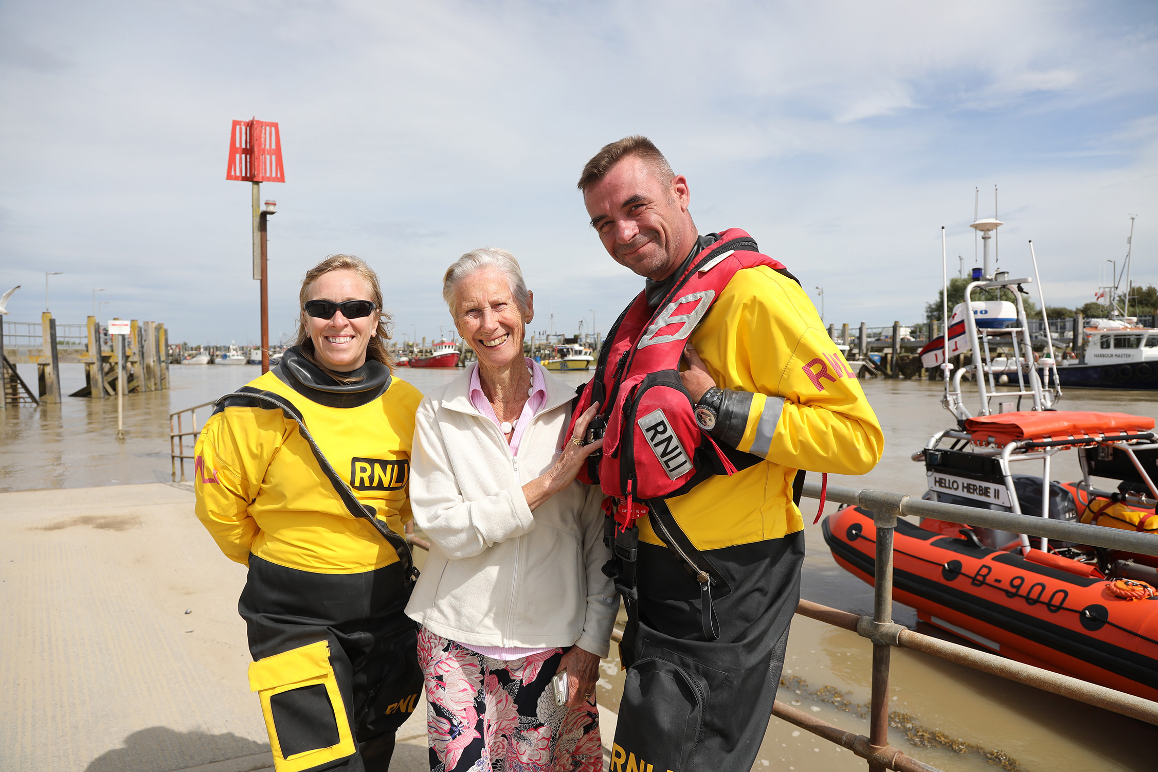 Crew members Sharon Gozna and Tony Peters stand either side of Sheila Pigott